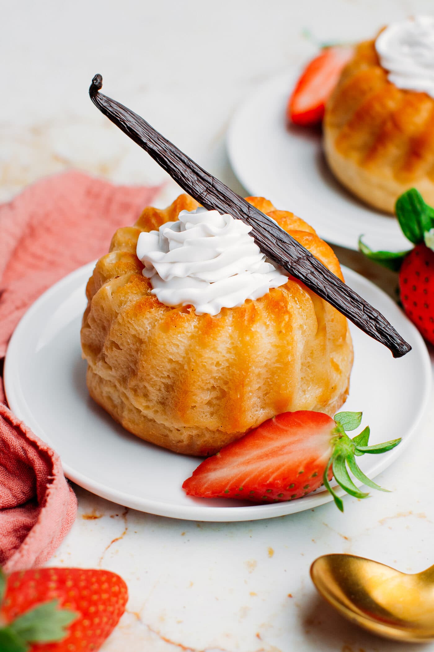 Rum baba topped with whipped cream and vanilla bean.