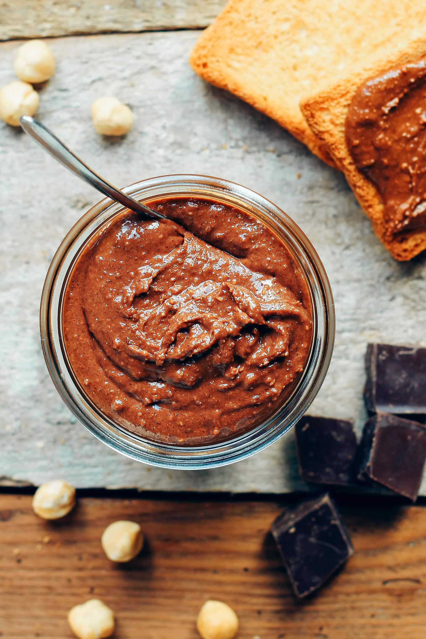 Jar of chocolate praline spread on a wooden table.