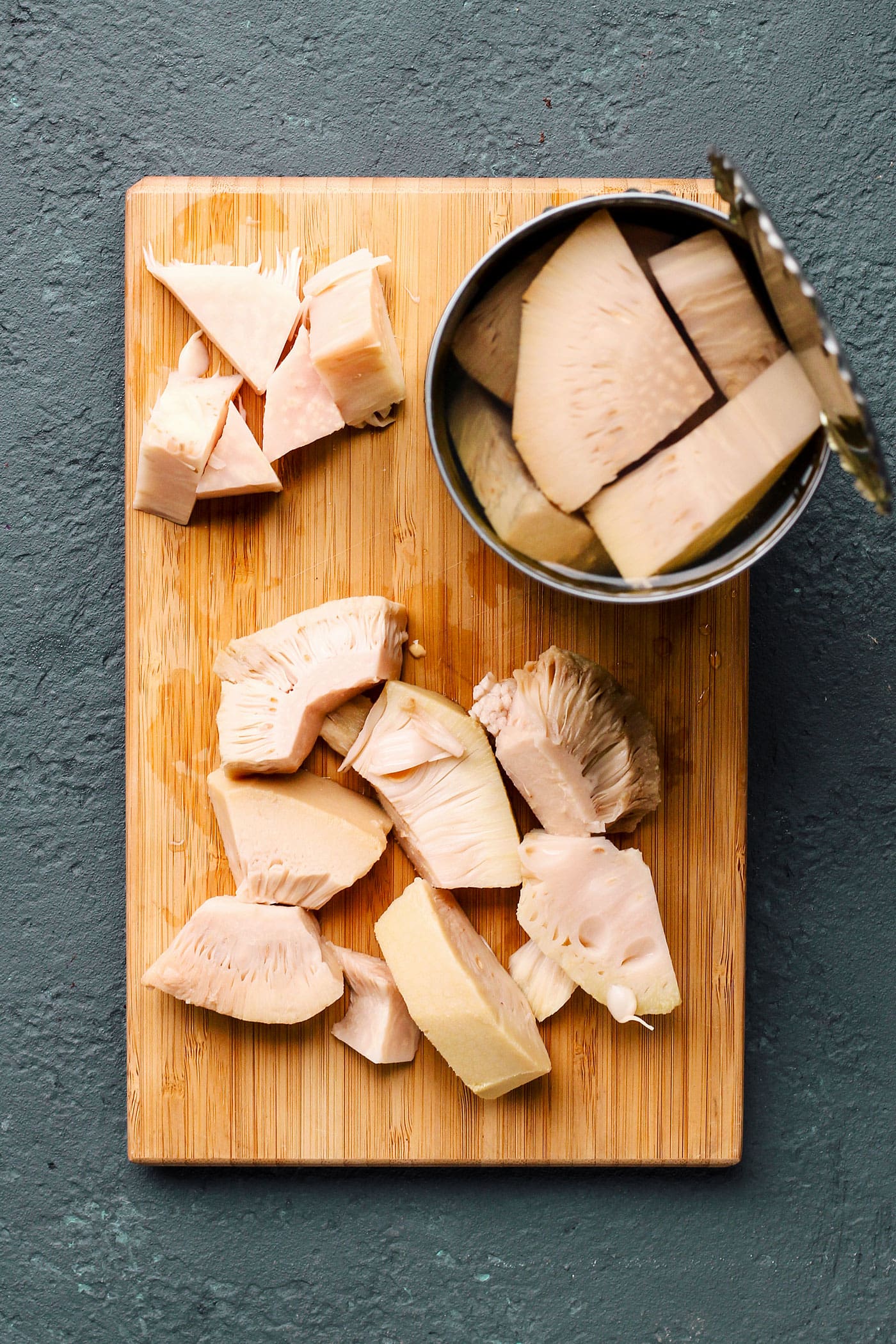 Jackfruit chunks on a wood cutting board.