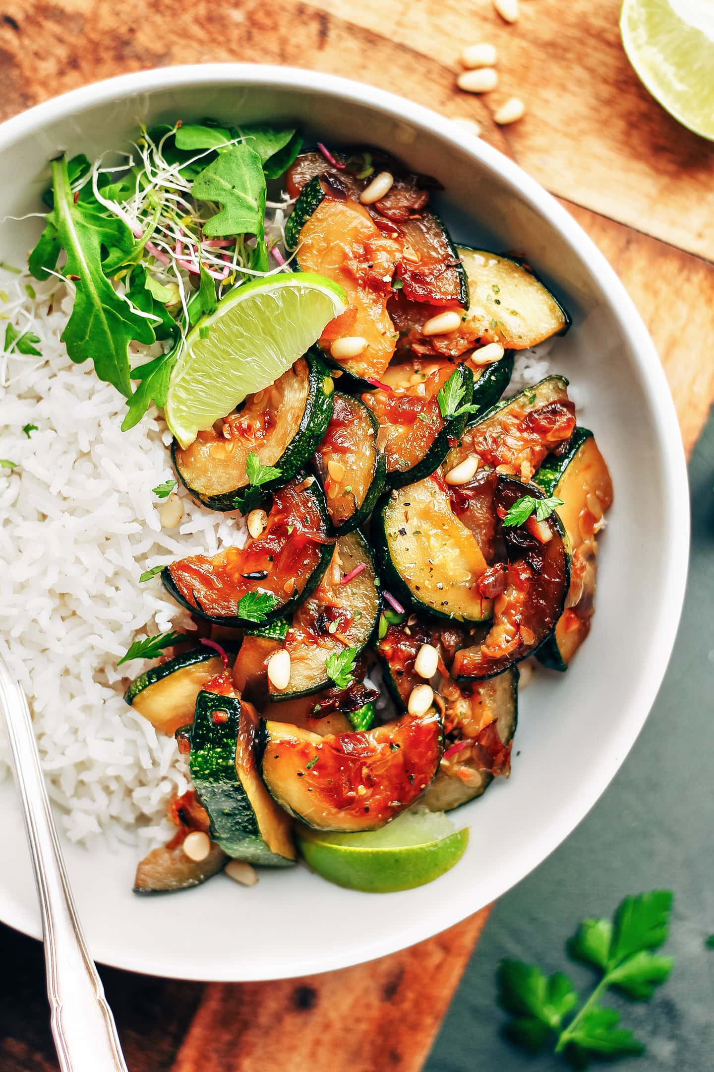 Close-up of caramelized zucchini slices on top of white rice.