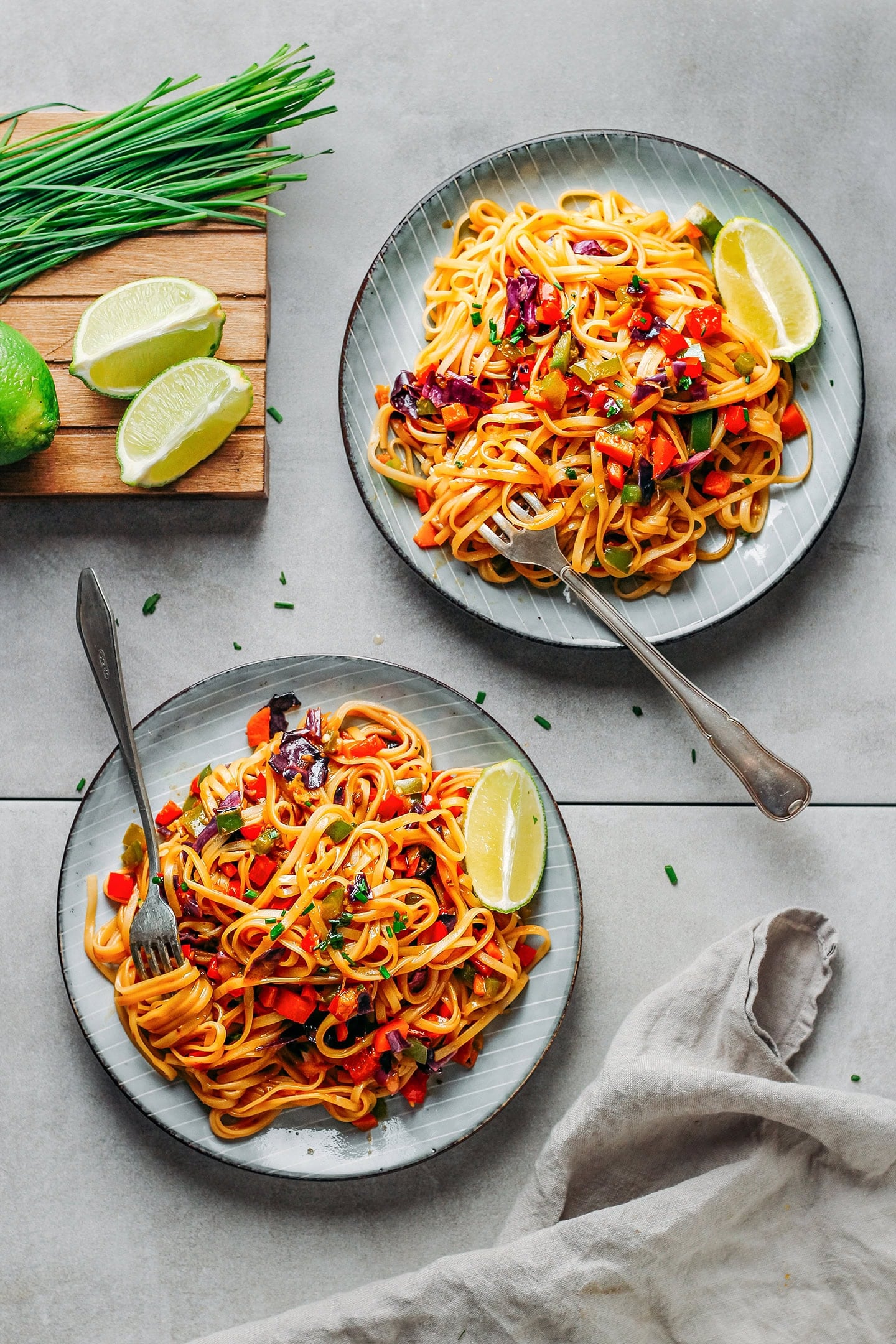 Two plates filled with sautéed sweet and spicy noodles.