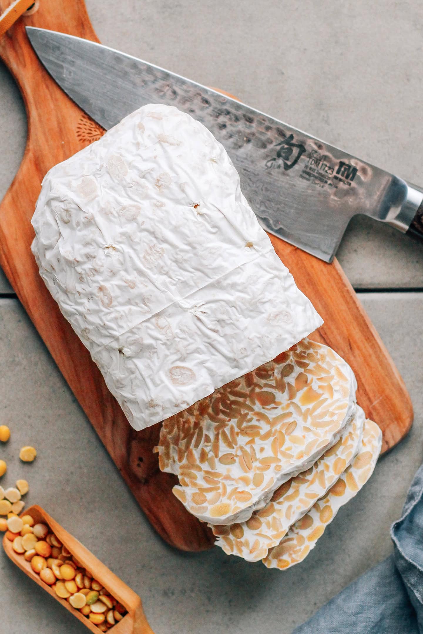 Loaf of soybean tempeh on a wooden board.