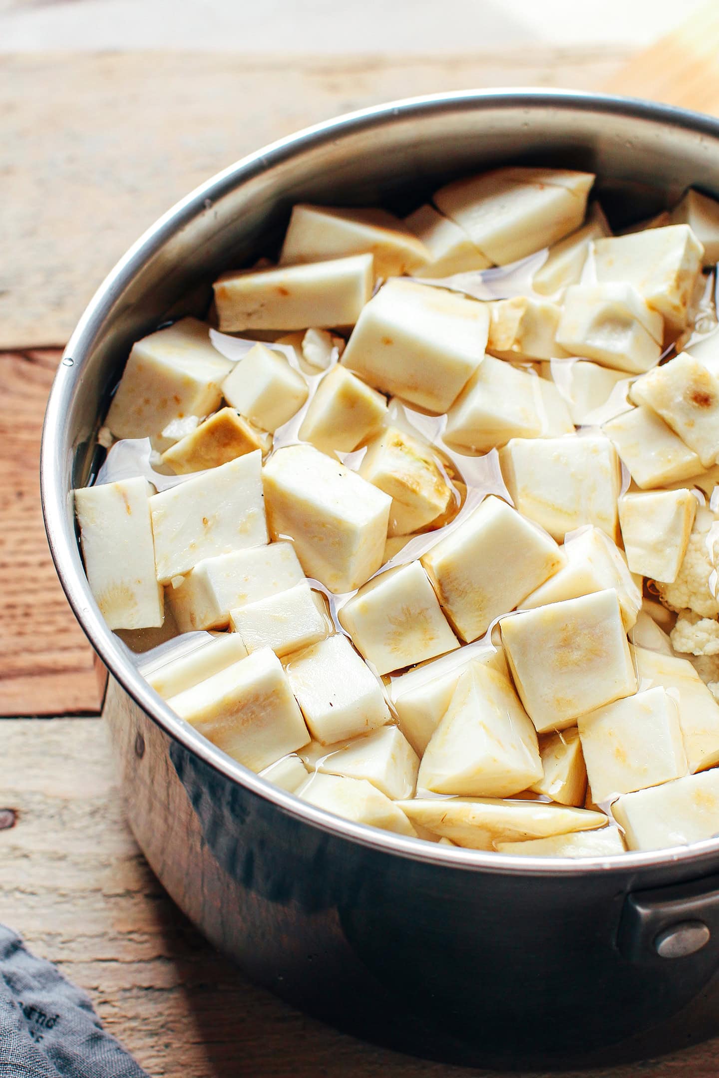 Diced celery root and cauliflower in a pot.