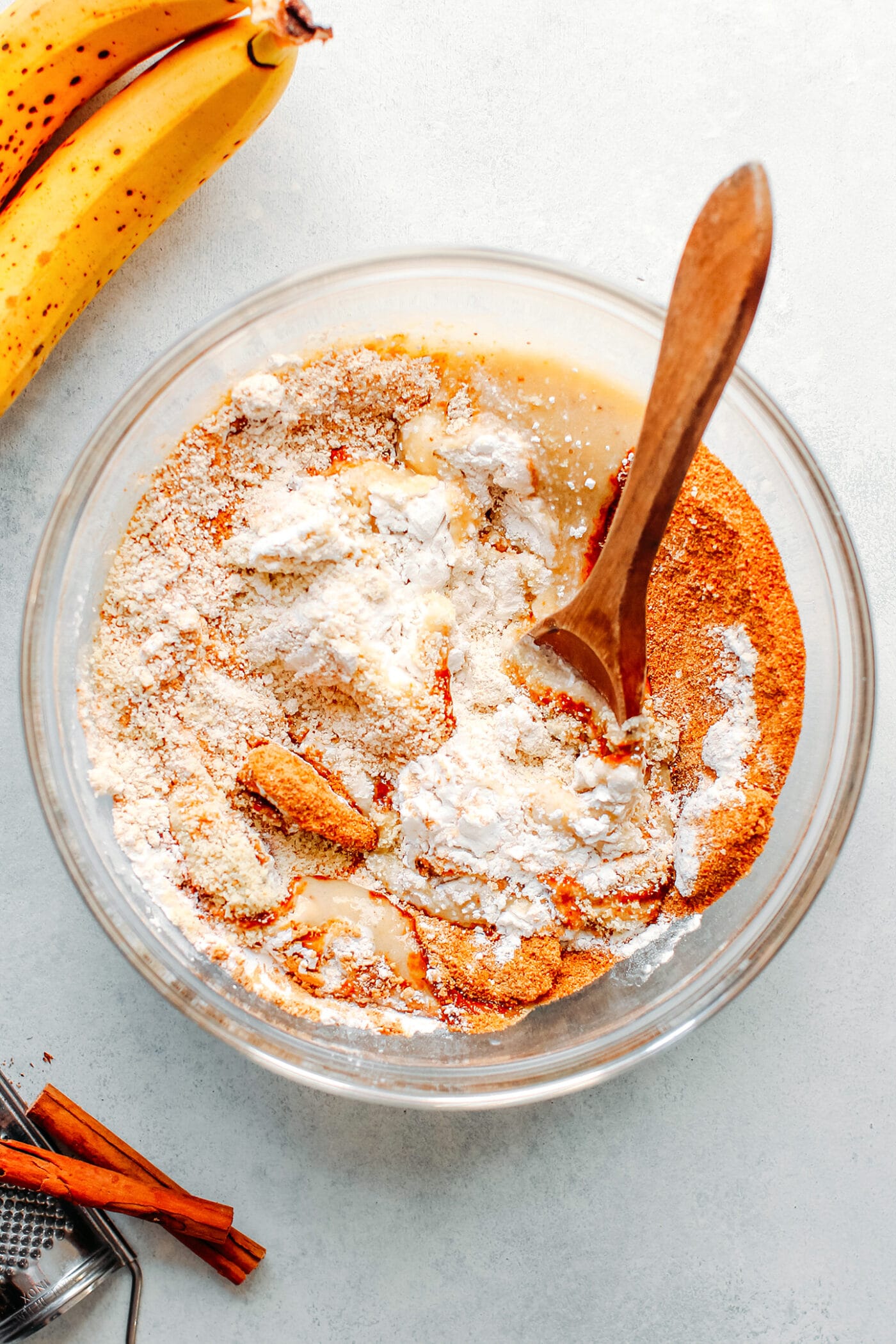 Whisking together flour, sugar, and mashed bananas.