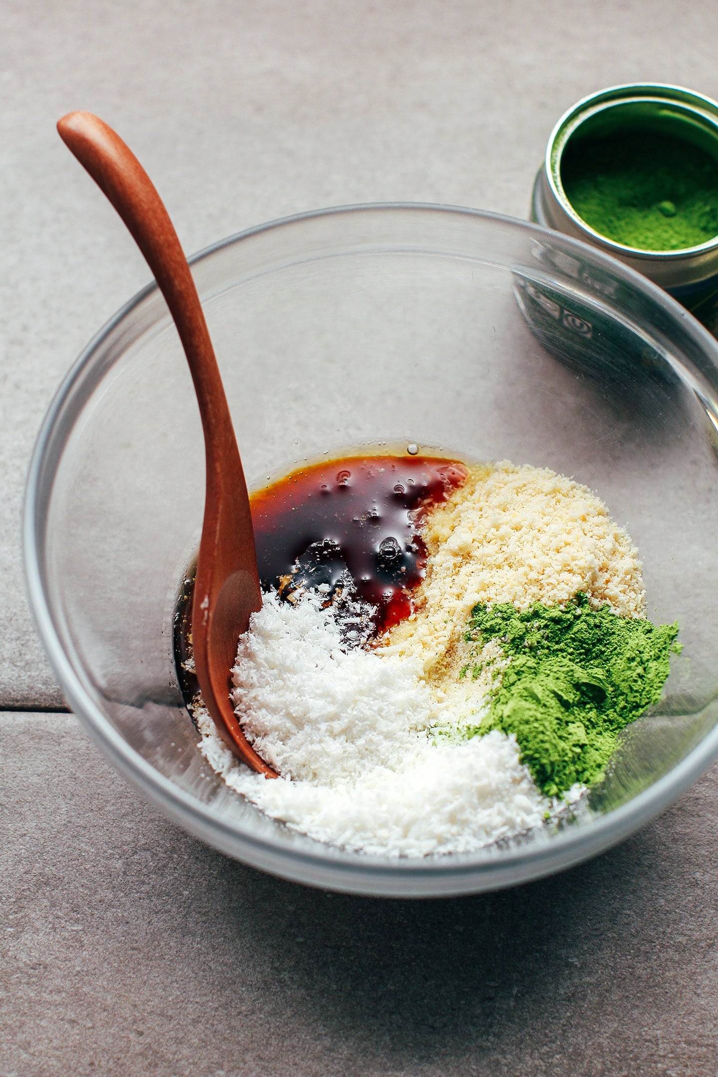 Shredded coconut, coconut syrup, matcha powder, and almond flour in a bowl.