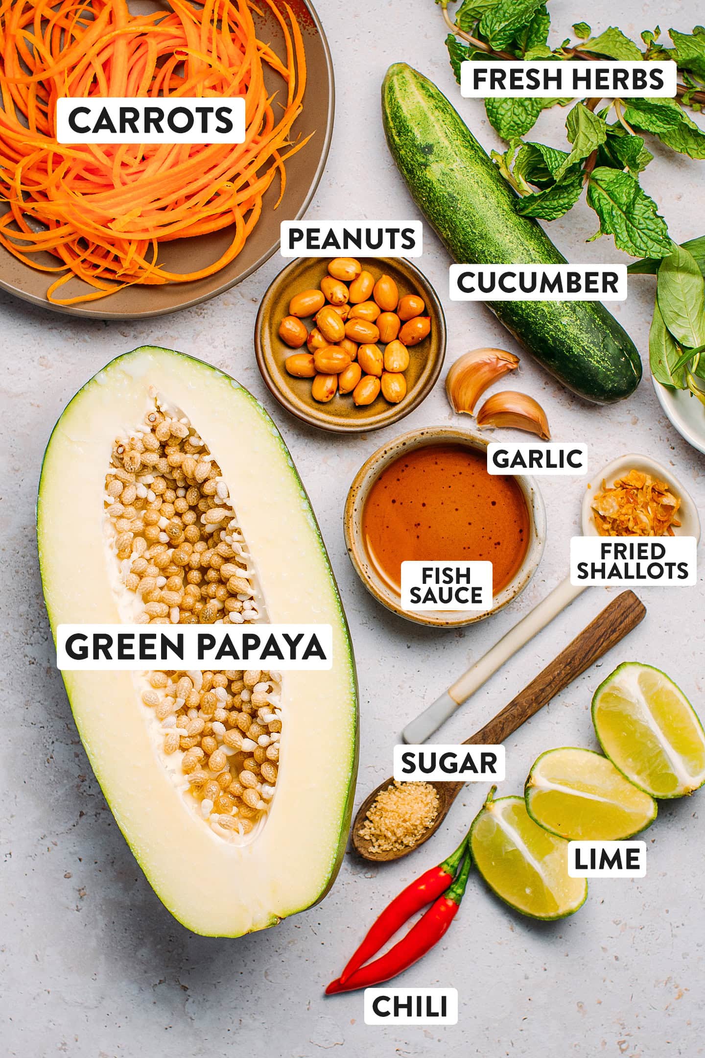 Ingredients like green papaya, cucumber, fish sauce, peanuts, and lime.