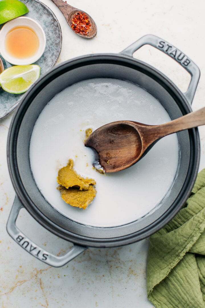 Green curry paste with coconut milk in a pot.