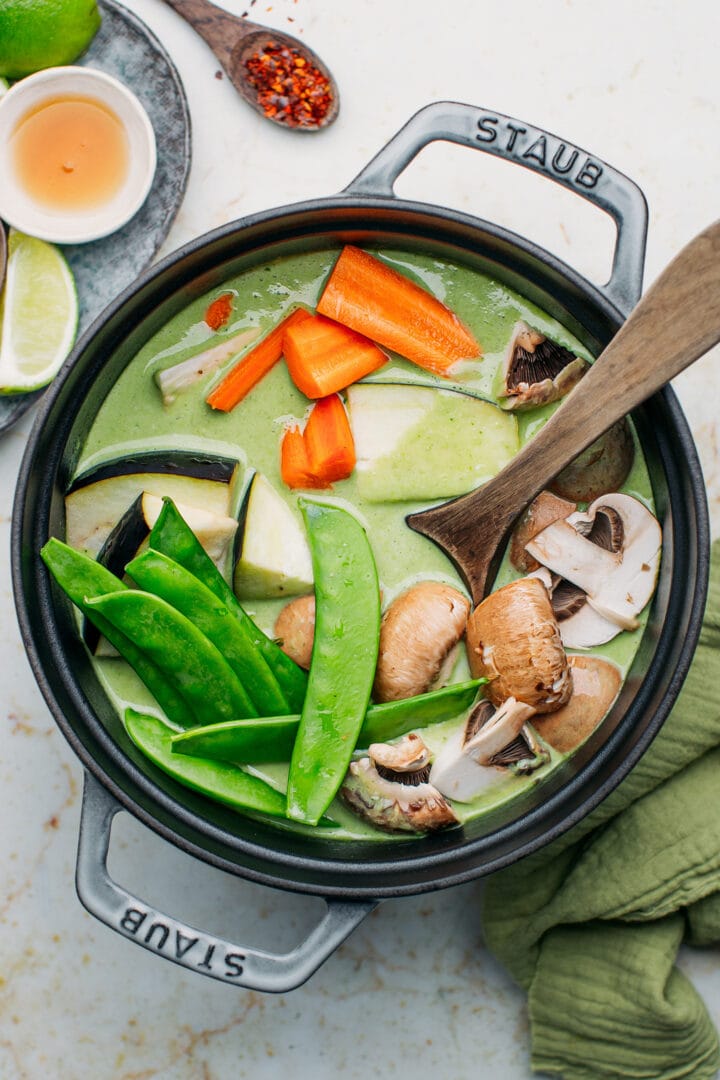 Snow peas, eggplants, mushrooms, and carrots in a pot.