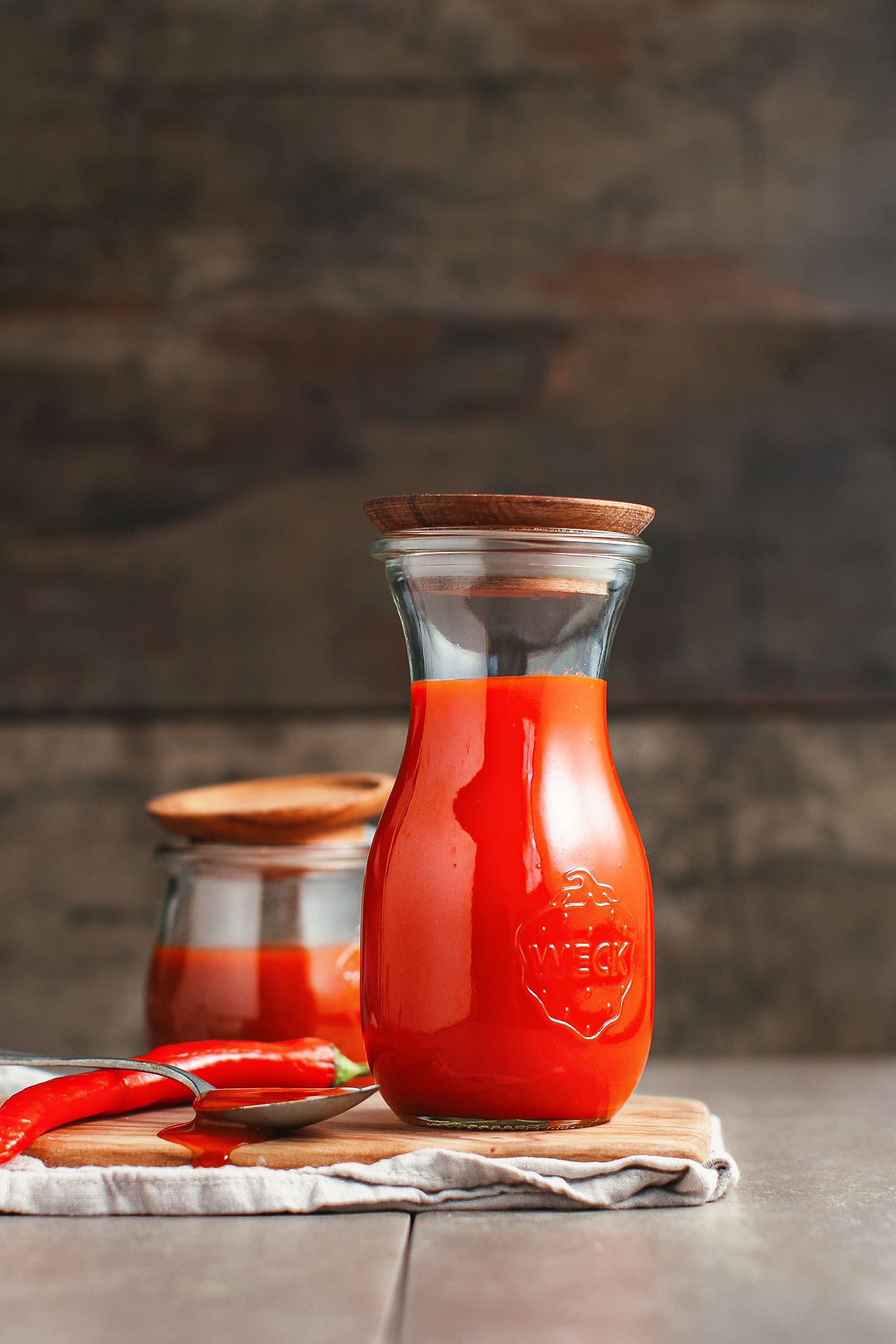 Bottle of homemade buffalo sauce on a wooden board.