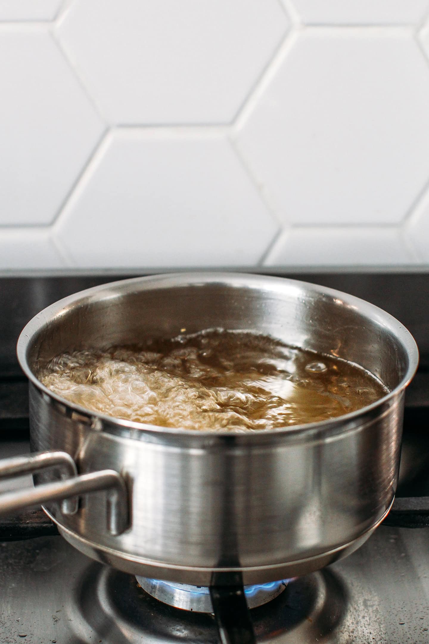 Deep frying a block of tofu in oil.