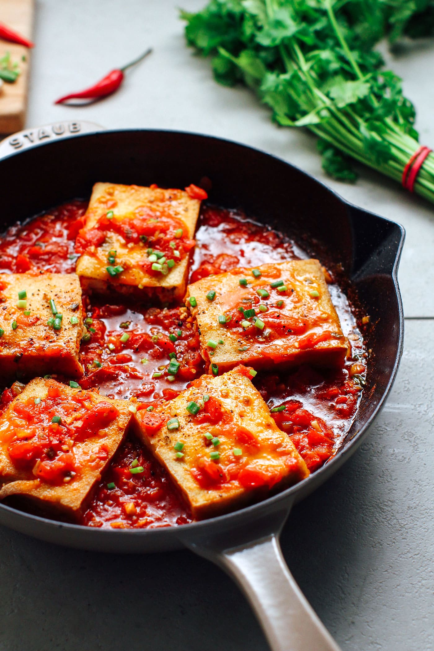 Five pieces of stuffed tofu in a tomato sauce.