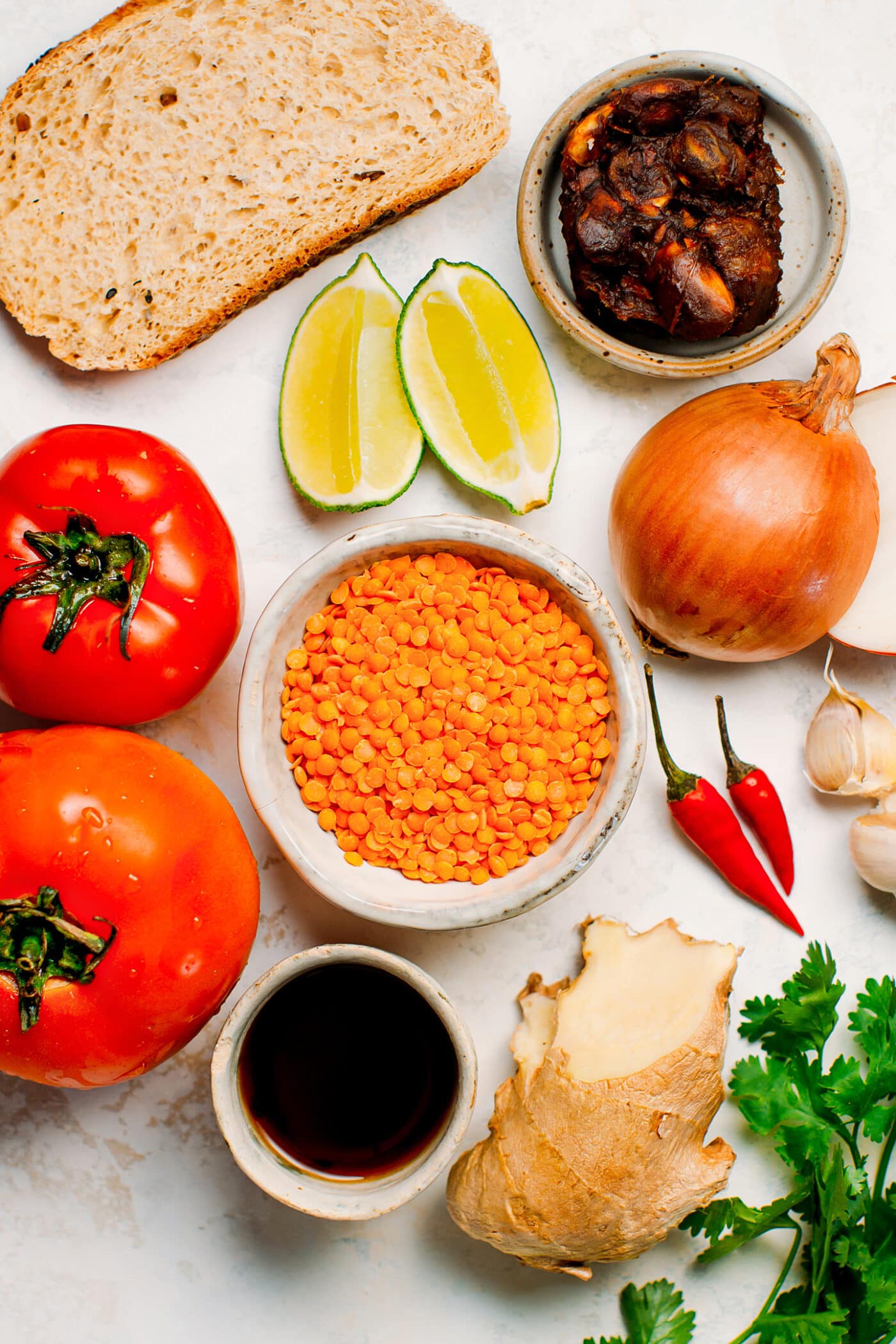 Ingredients like red lentils, tomatoes, onion, garlic, ginger, and tamarind.