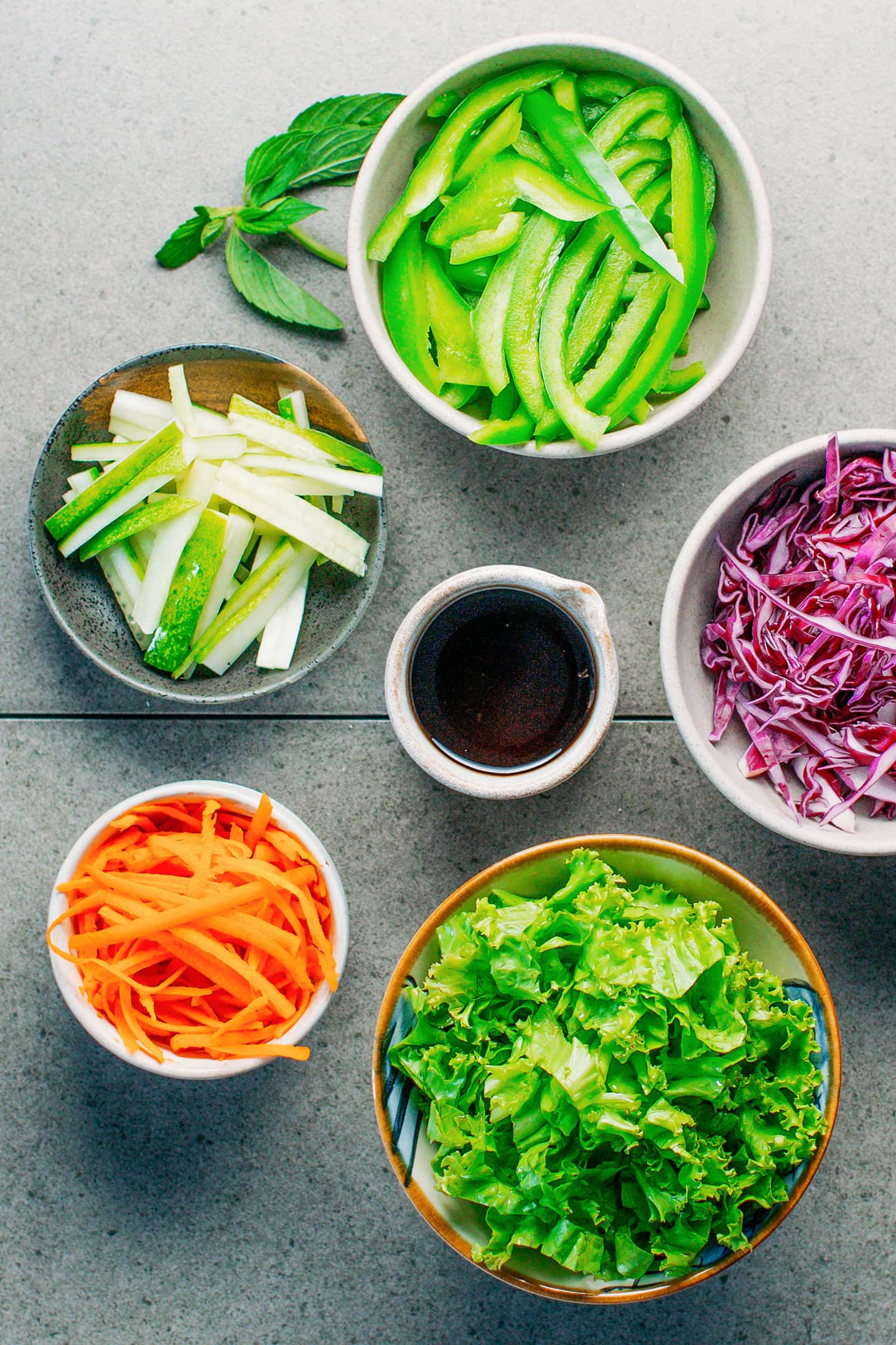 Chopped cucumbers, bell peppers, red cabbage, and carrots.