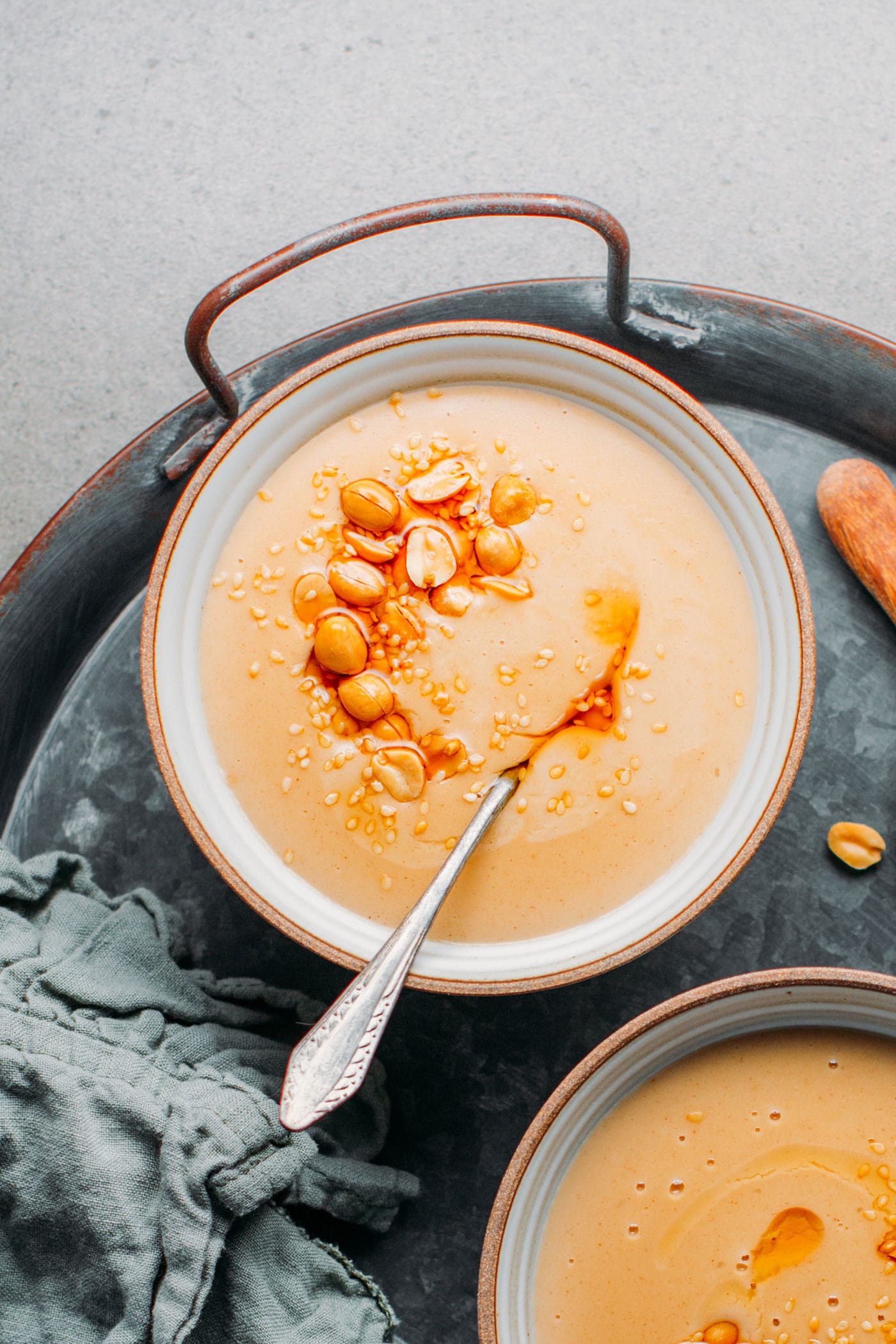Bowl of sweet peanut soup topped with roasted peanuts.