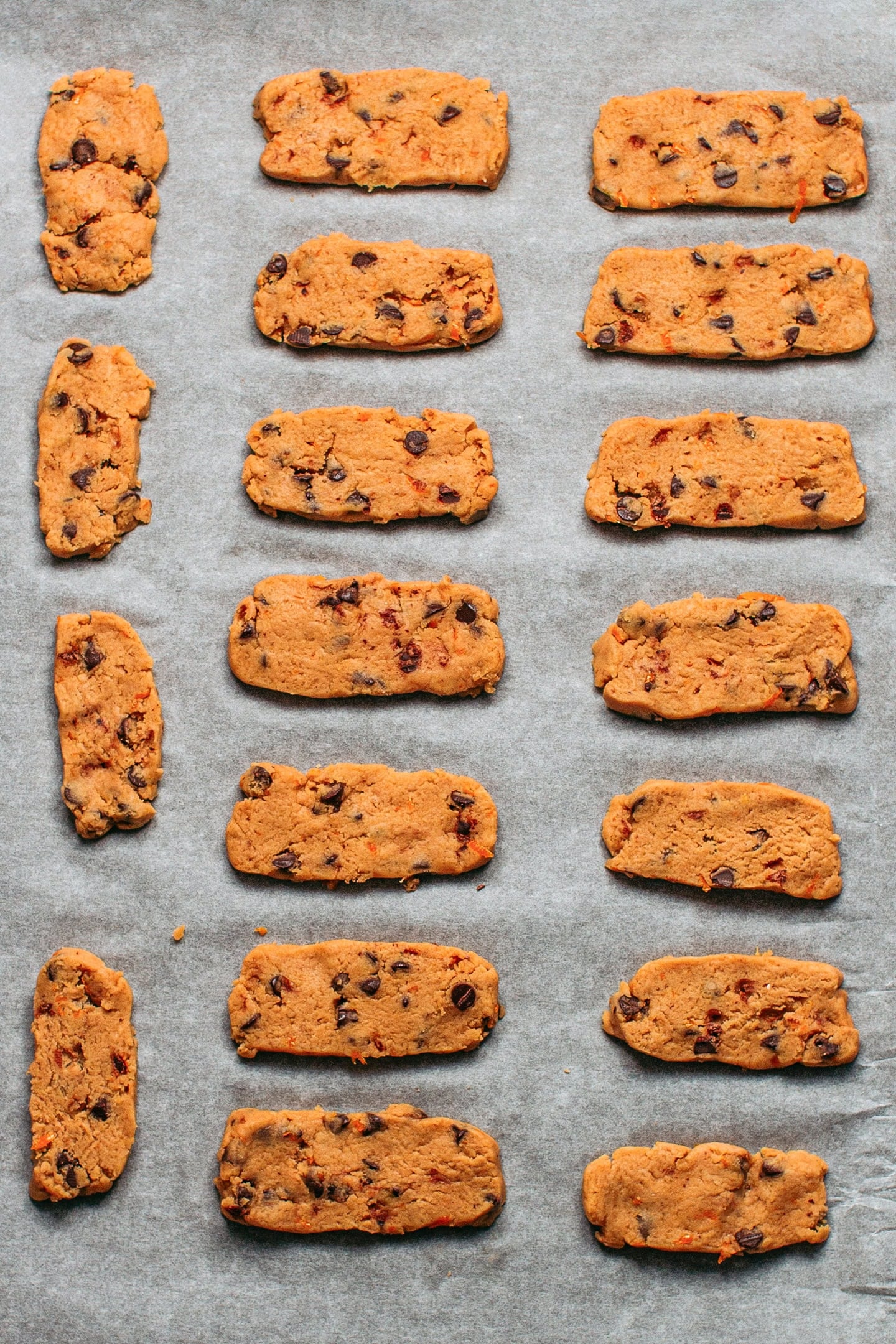 Unbaked long shortbread cookies on a baking sheet.