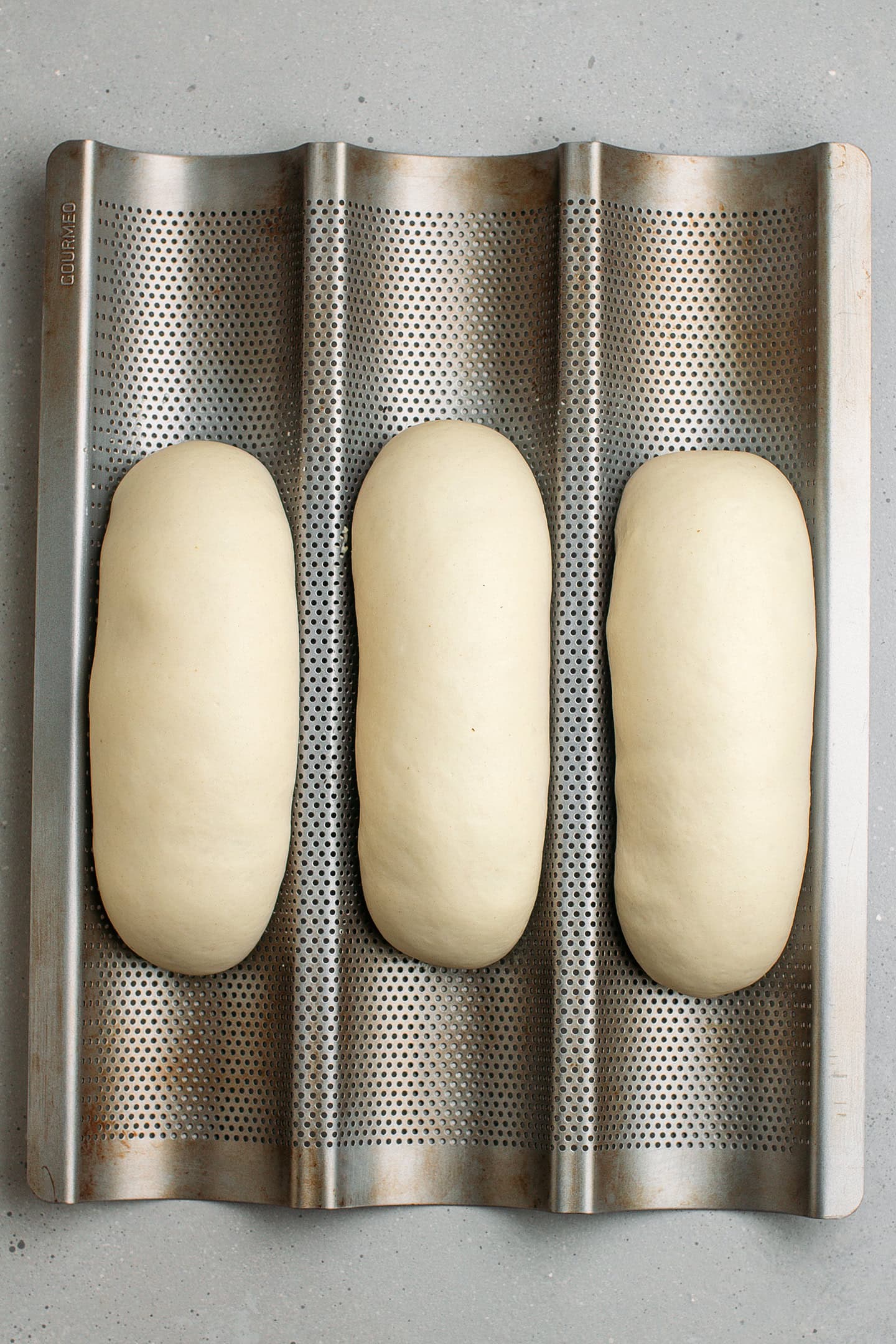 Unbaked banh mi on a baguette pan