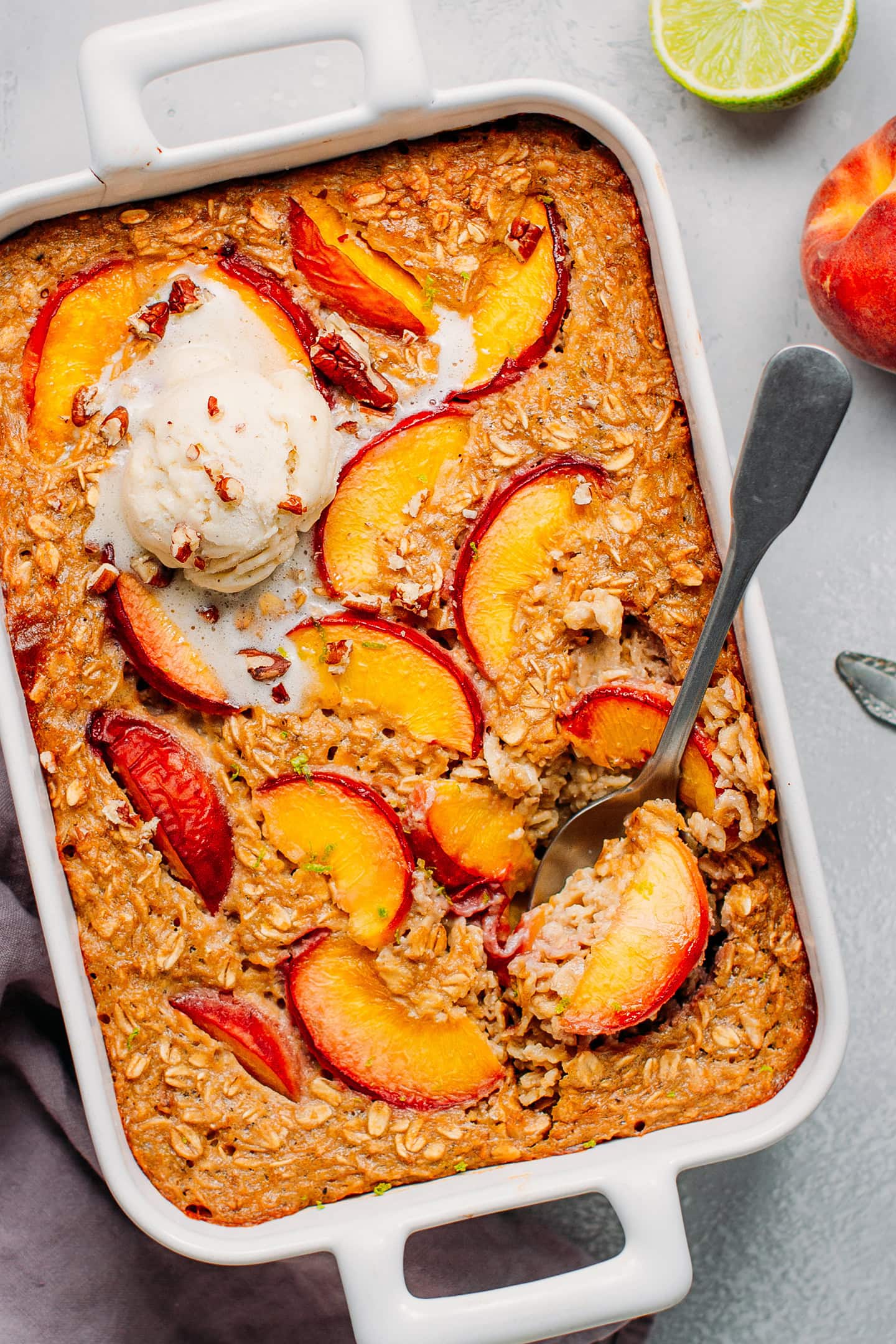 Baked Oatmeal casserole topped with peaches and ice cream.
