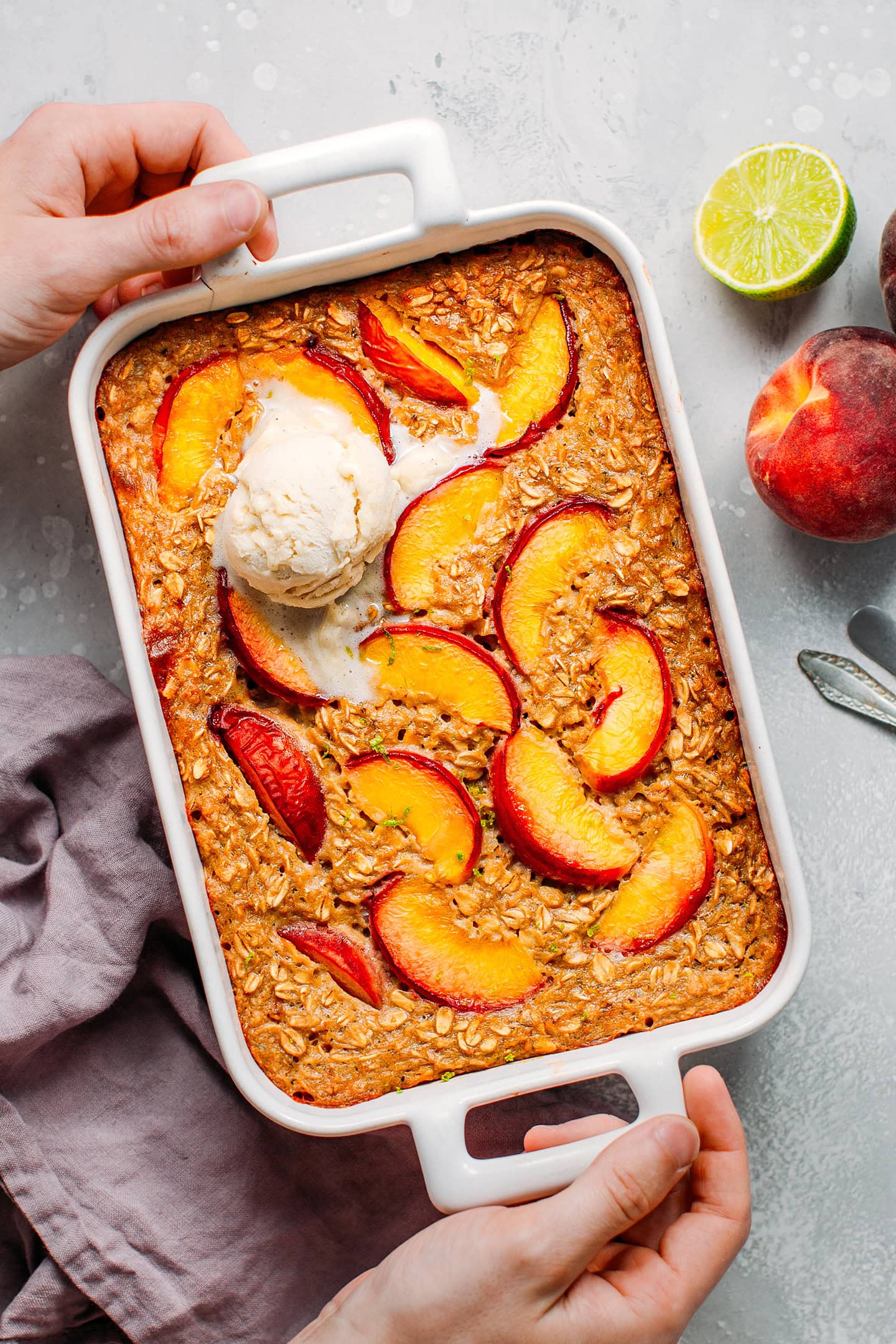 Peach baked oatmeal topped with a scoop of vanilla ice cream.