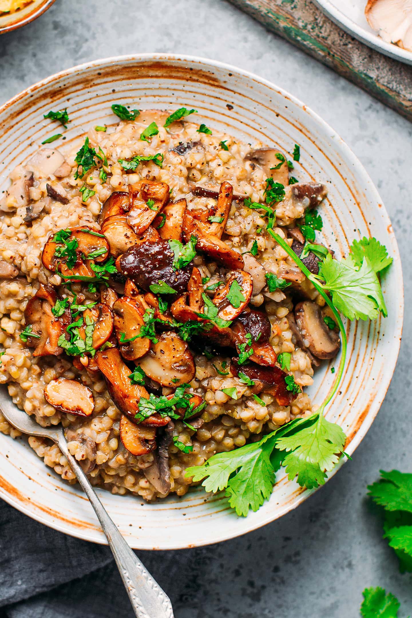 Buckwheat groats risotto topped with sautéed mushrooms in a bowl.