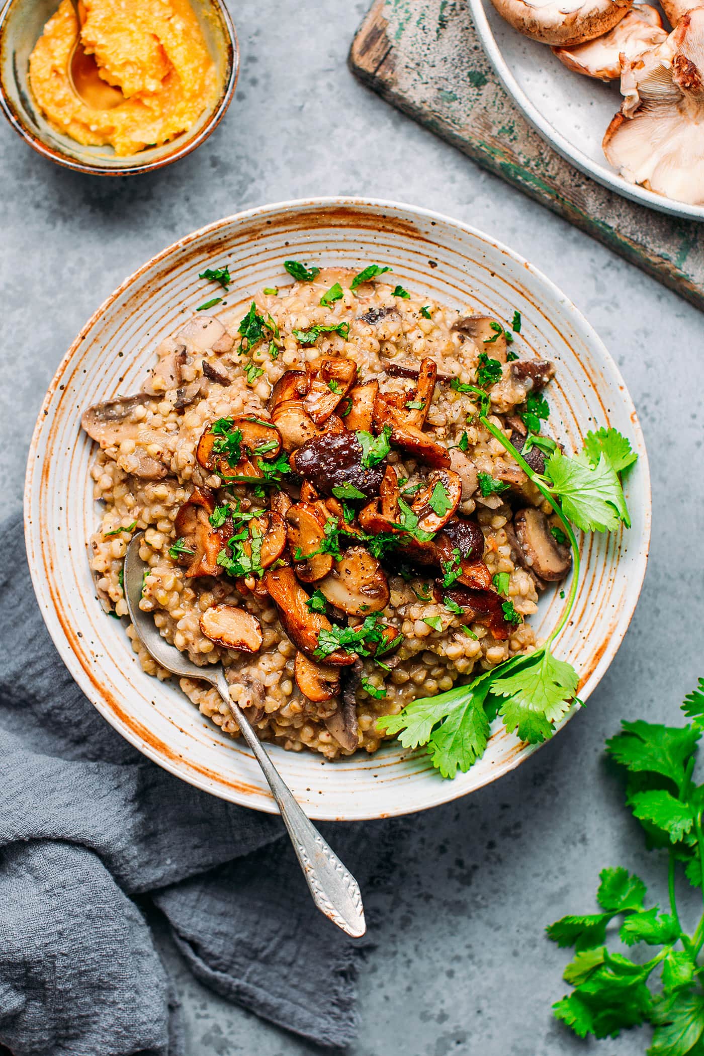 Buckwheat risotto with mushrooms and chopped cilantro in a bowl.