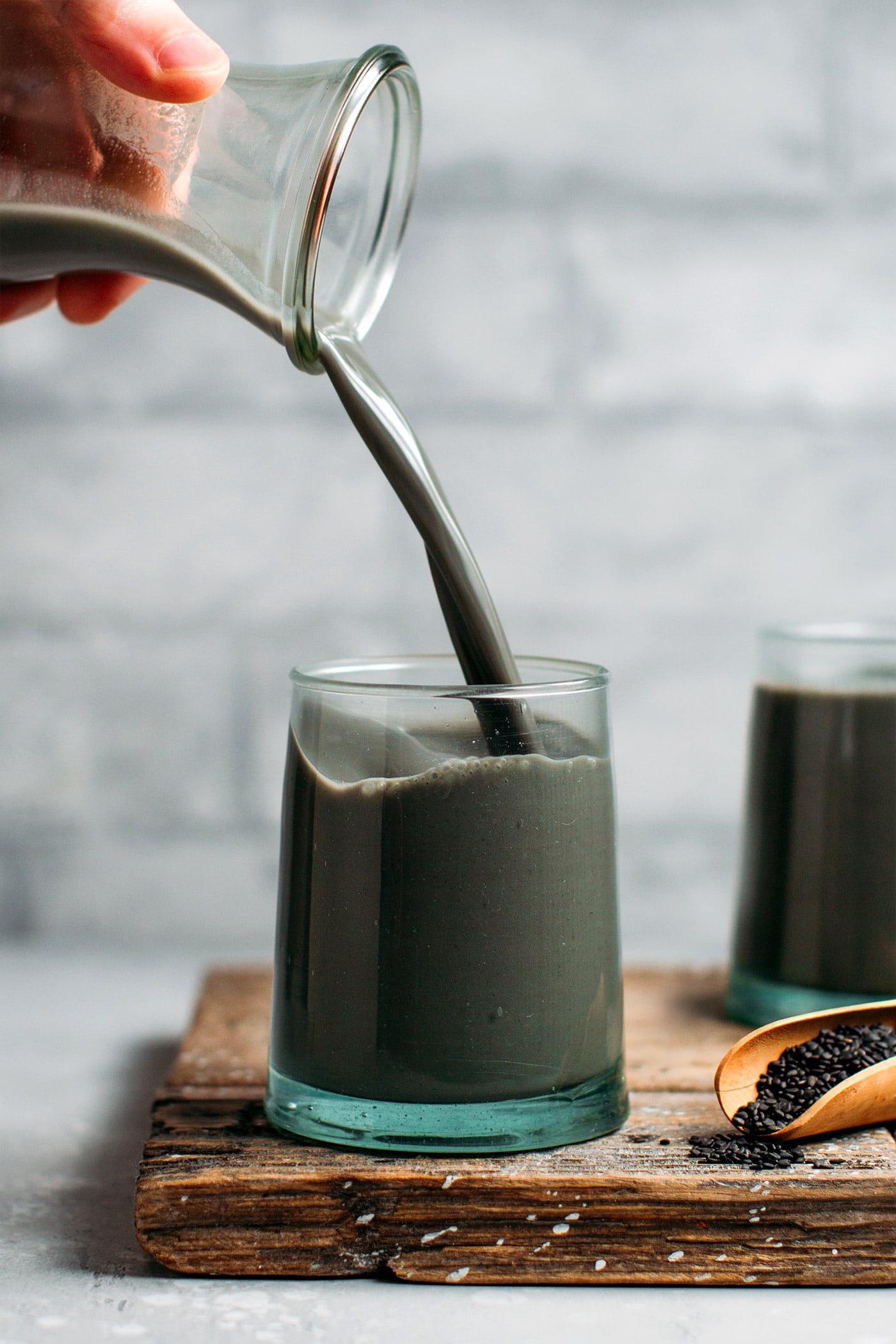 Pouring black sesame milk into a glass.
