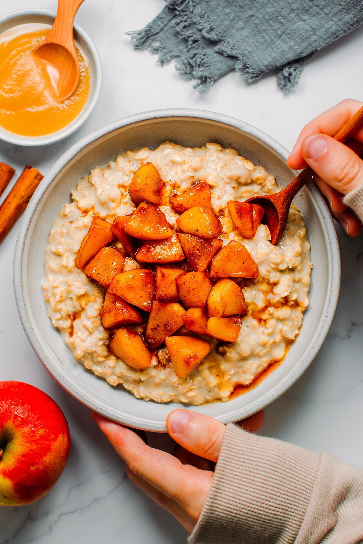 Deep plate filled with cinnamon oatmeal and tender sautéed apples.