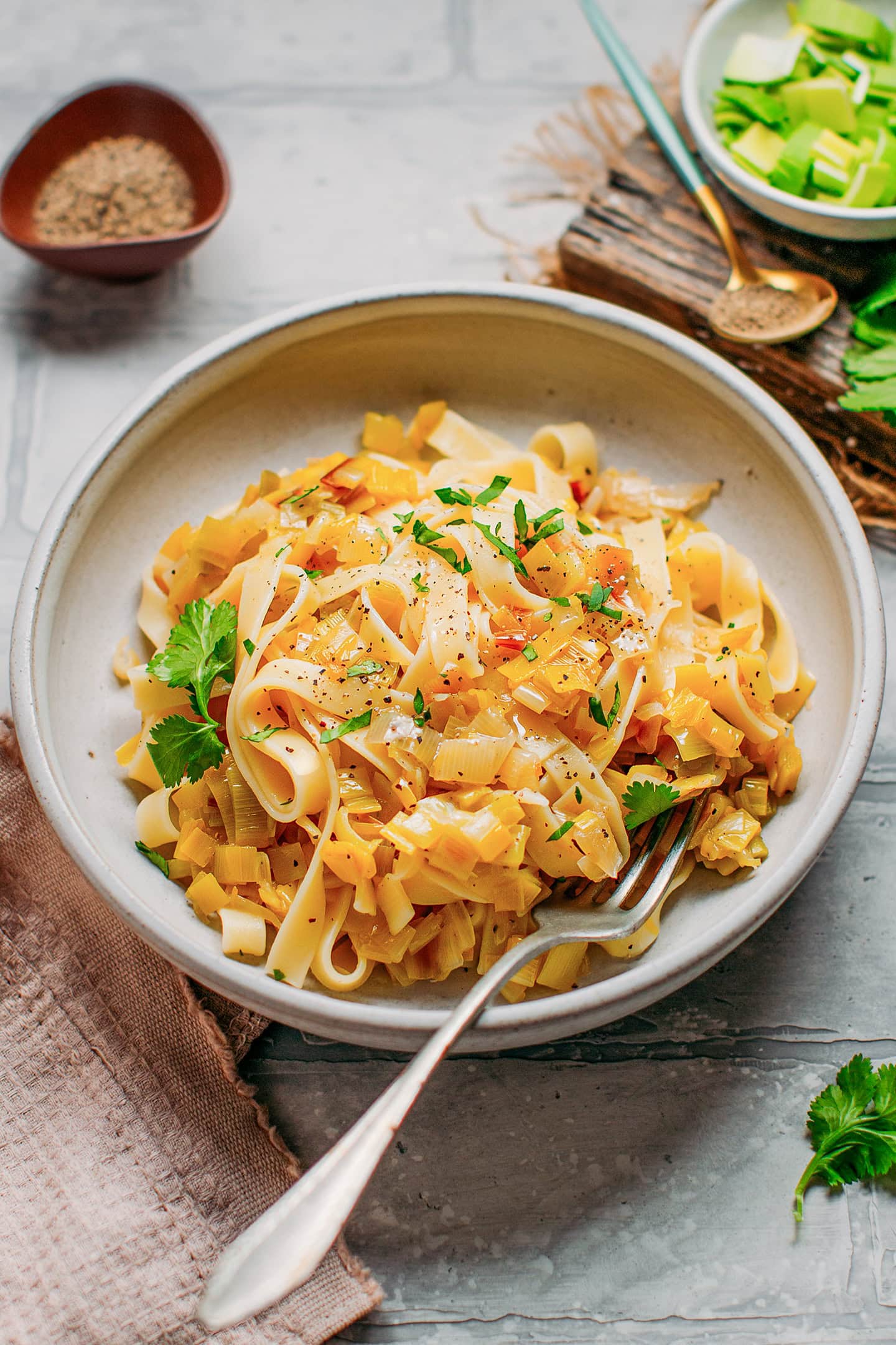 Tagliatelle tossed with sautéed leeks in a plate.