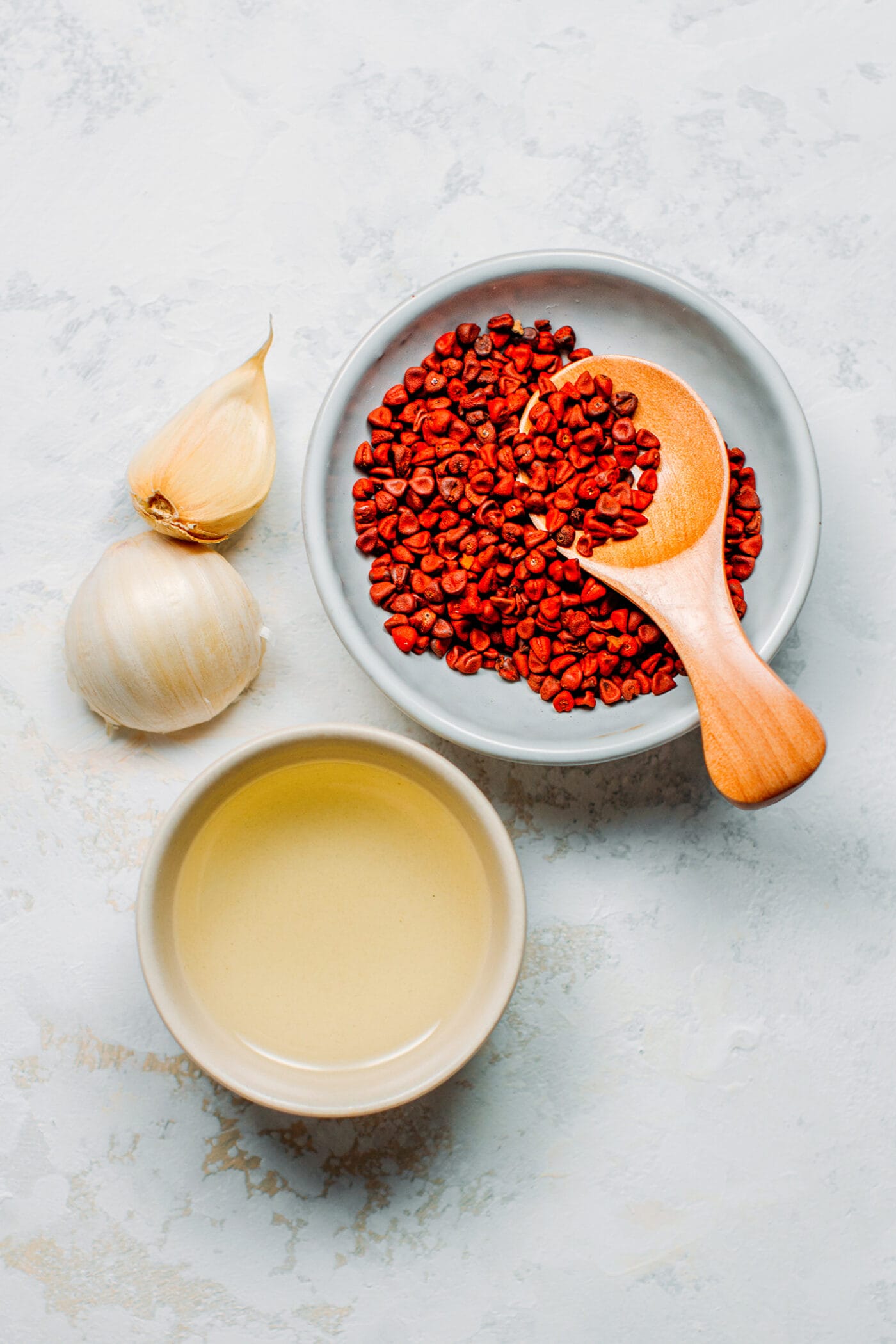 Ingredients like annatto seeds, oil, and garlic.