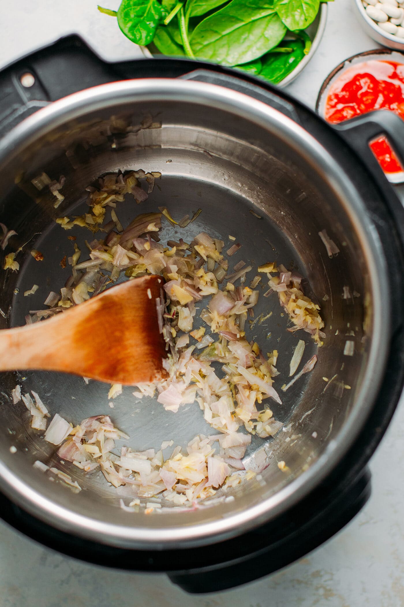 Cooking shallots, garlic, and ginger in the Instant Pot.