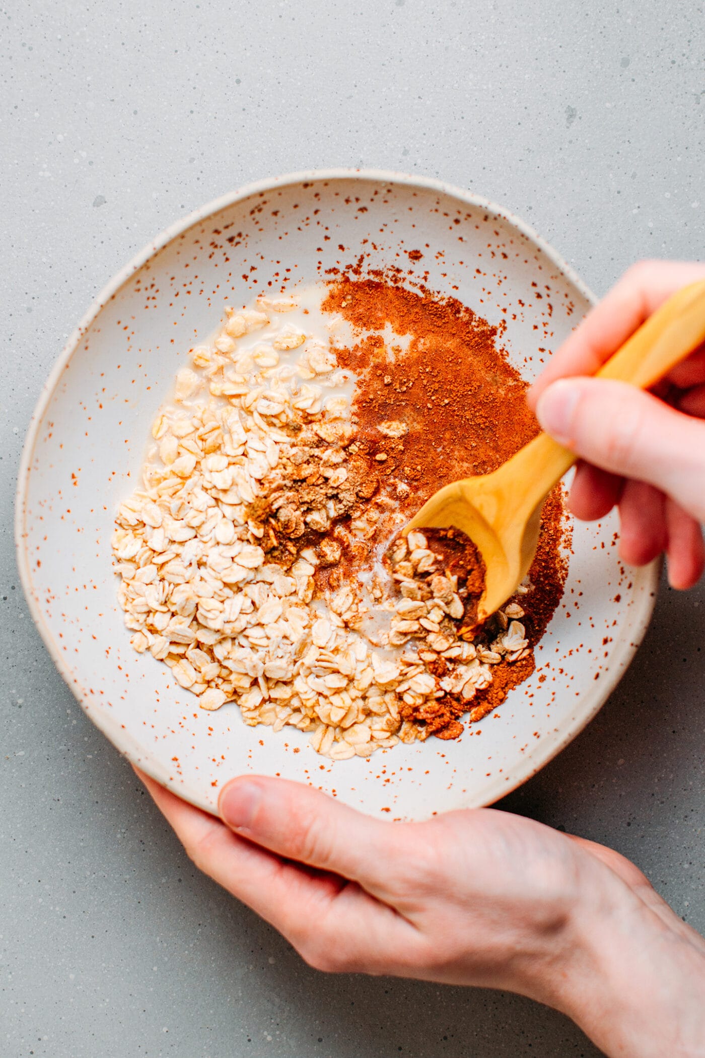 Whisking together rolled oats, almond milk, spices, and brewed black tea.