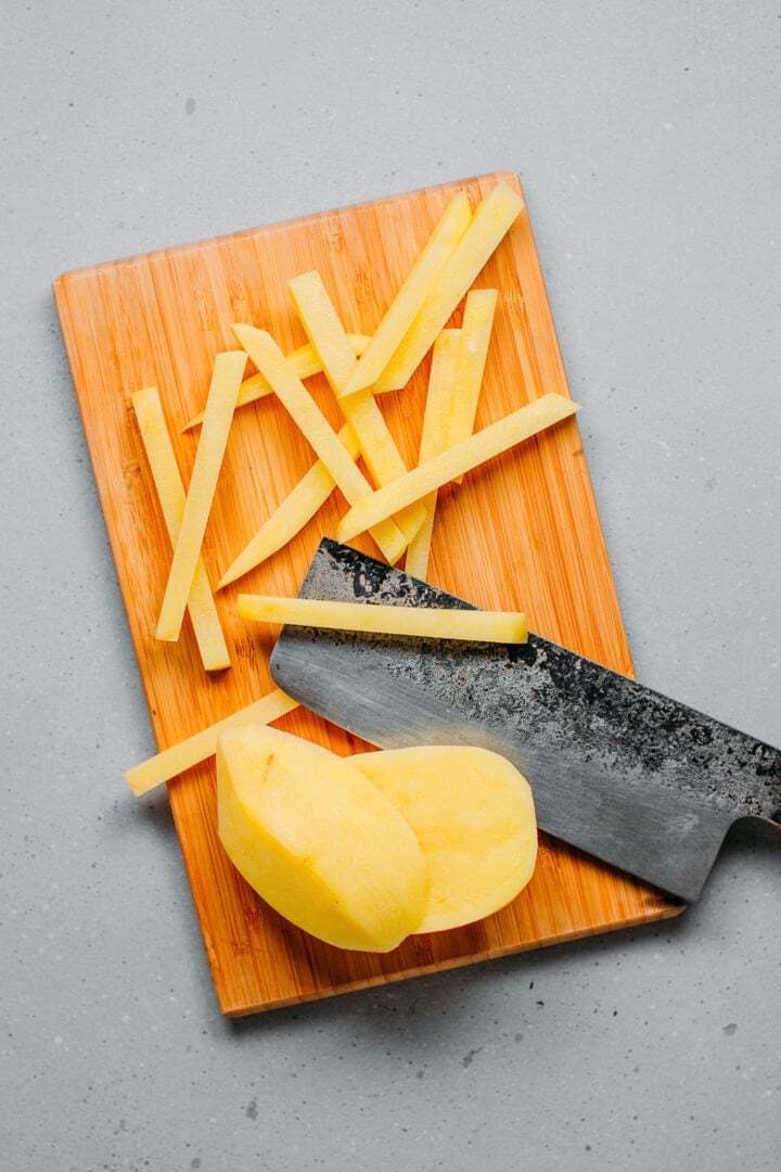 Cutting potatoes to make fries.