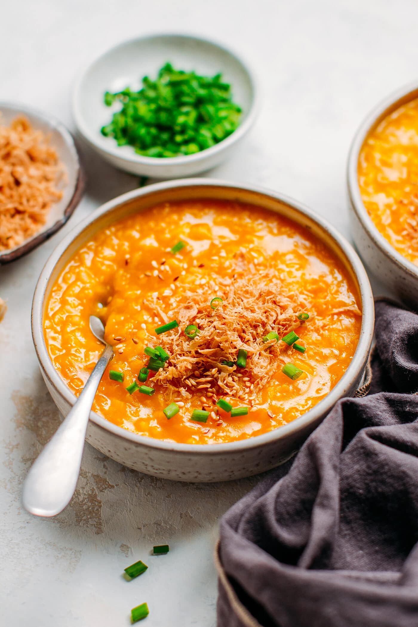 Pumpkin congee in a bowl with green onions.