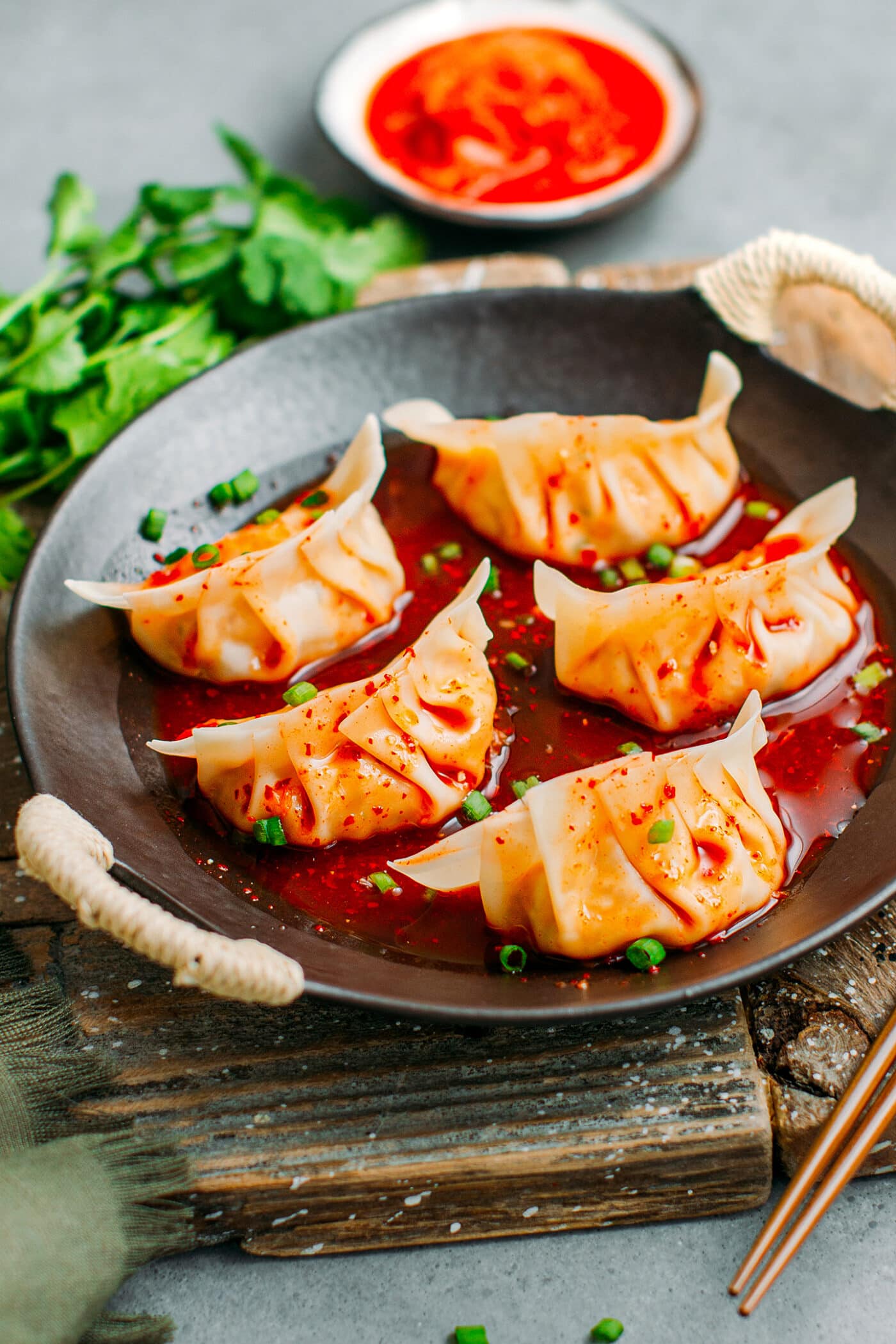 Vegan kimchi dumplings in a plate with kimchi juice.