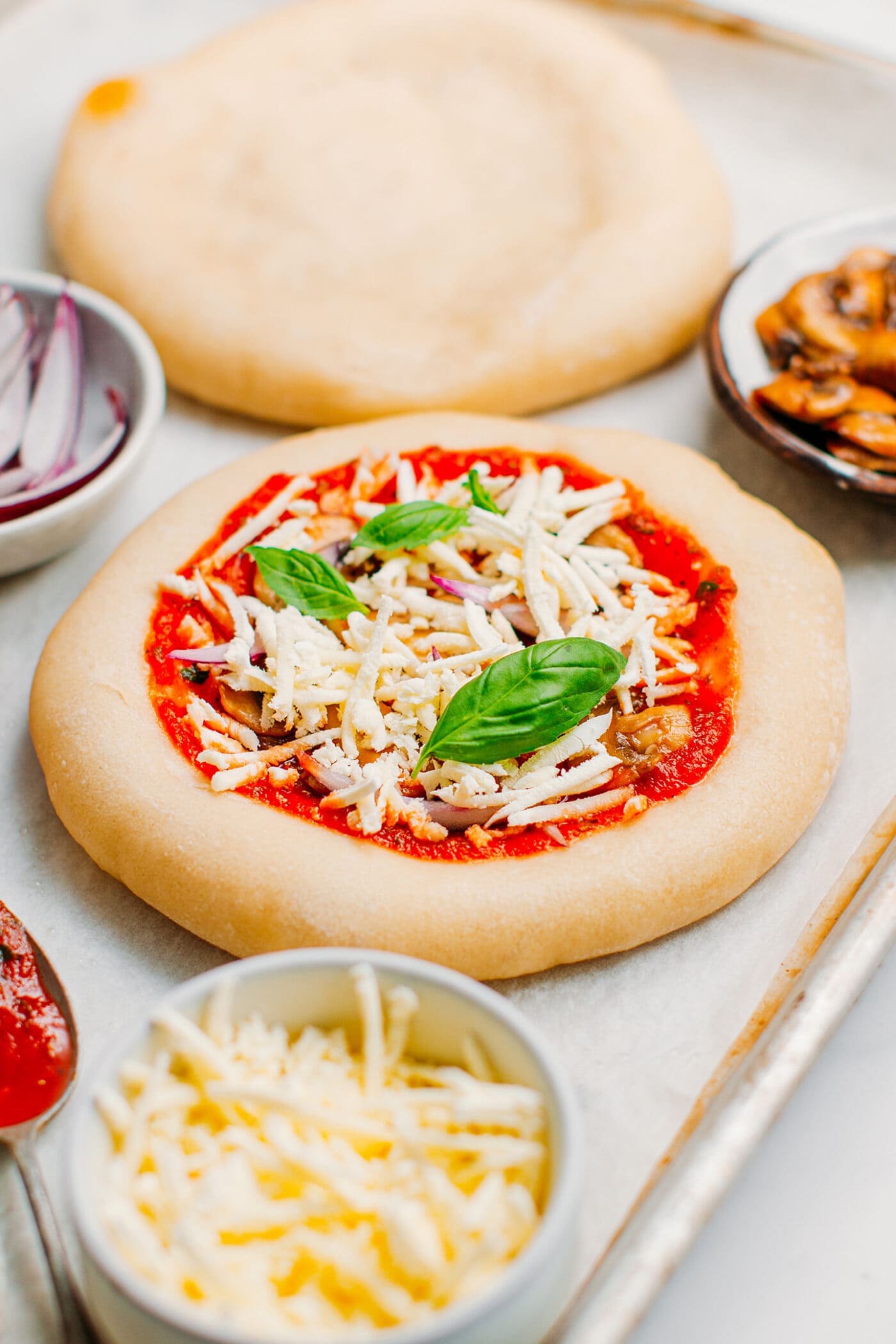 Bar baked pizza with tomato sauce, shredded vegan cheese, and basil.