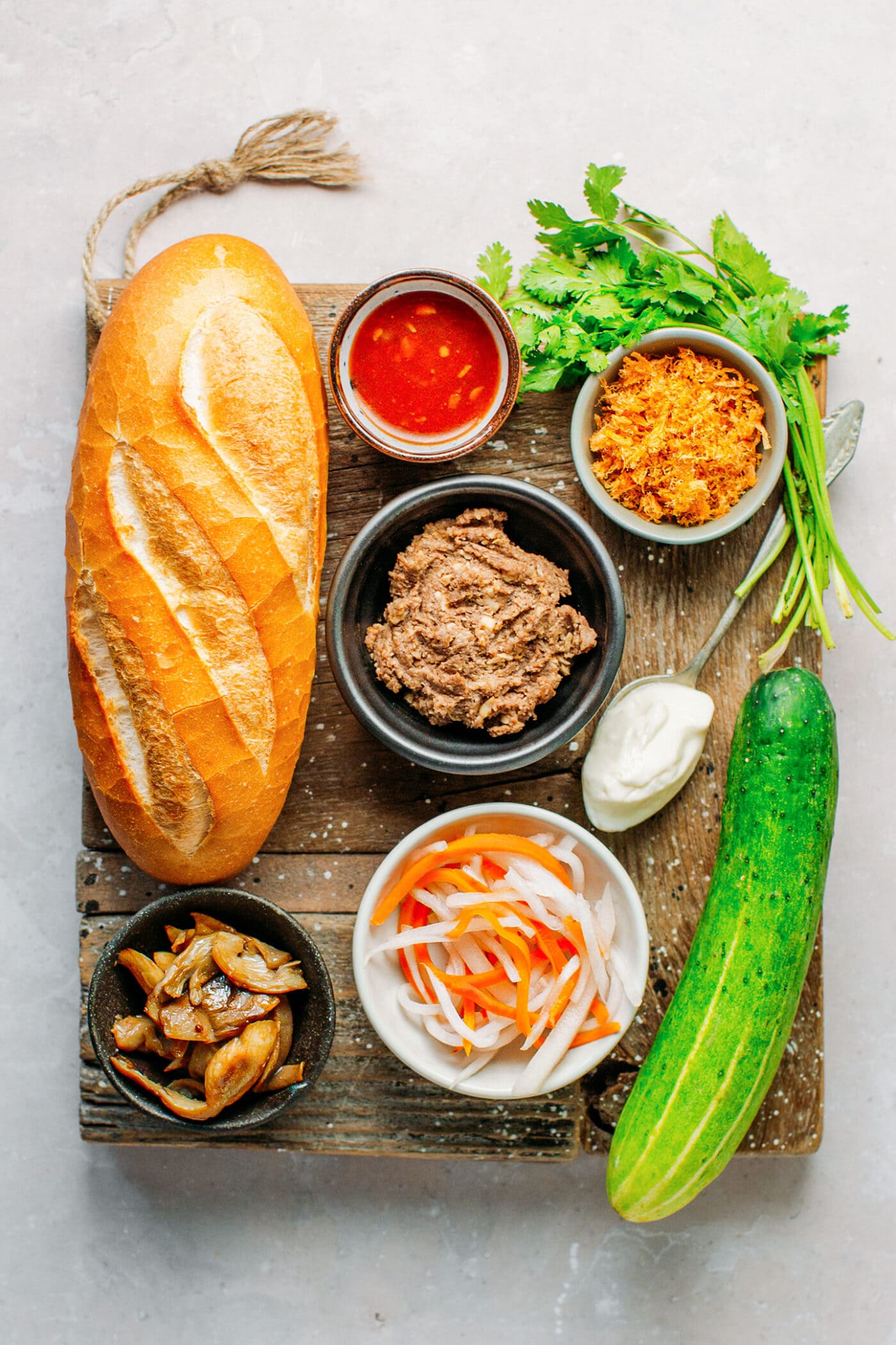 Ingredients like bread, paté, pickles, mayo, cucumber, mushrooms, and cilantro.