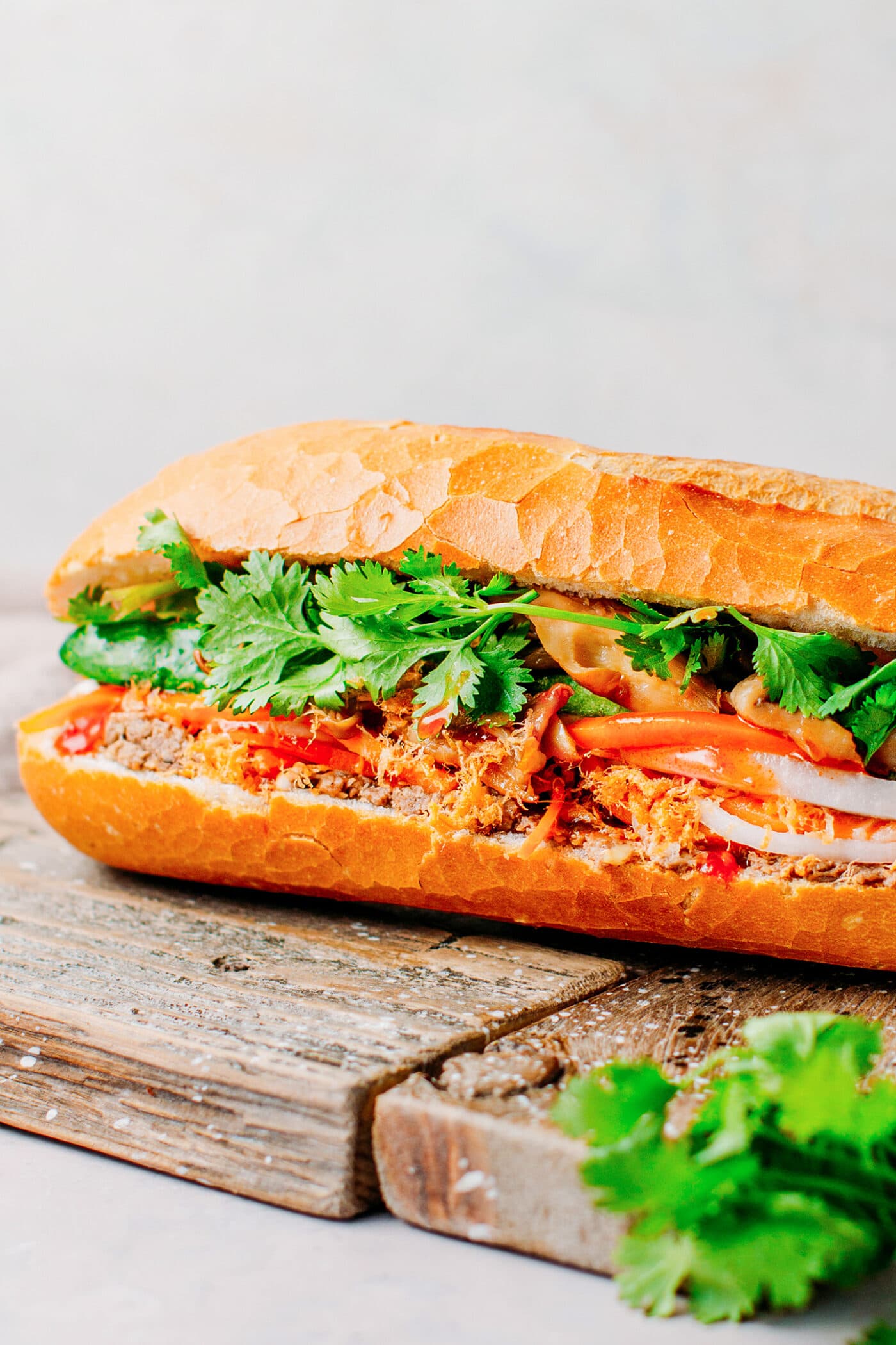 Vegan banh mi sandwich with cilantro, paté, pickles, and mushrooms.