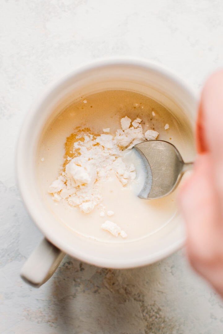 Preparing a mug cake batter in a mug.