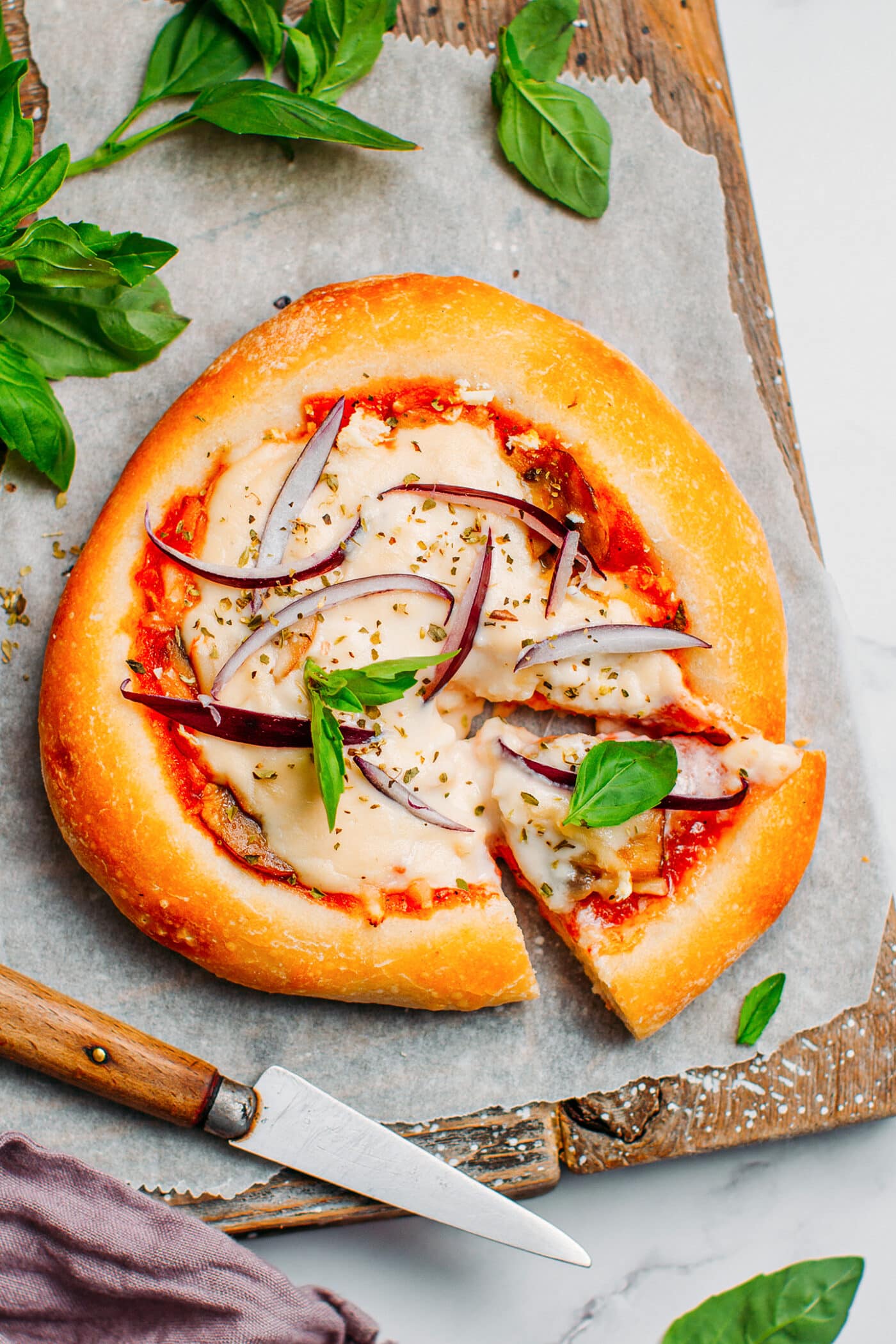 Mini vegan pizza with mushrooms, cheese, onions, and basil.