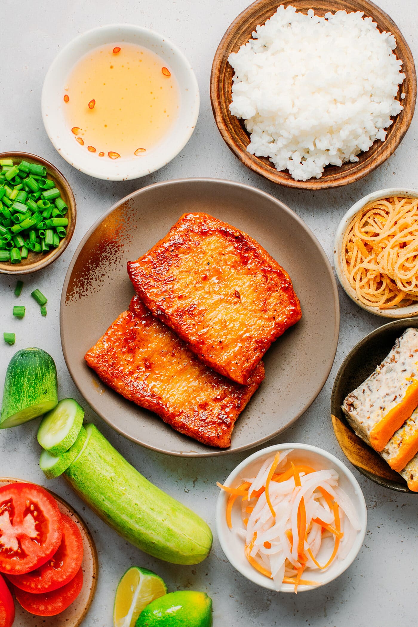 Ingredients like cucumber, pickles, tofu loaf, char siu ribs, and green onions.