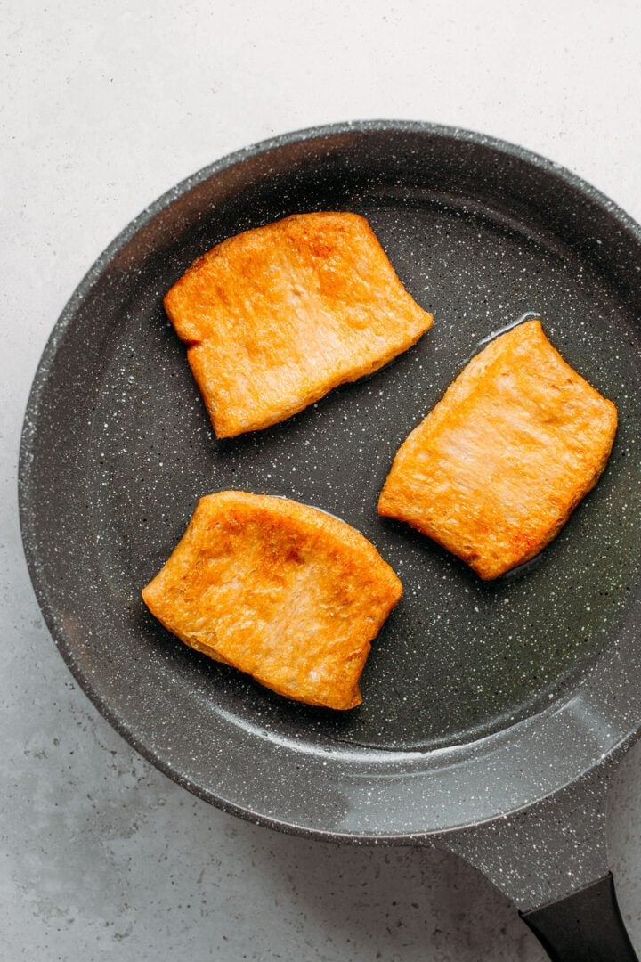 Frying large TVP slices in a skillet.