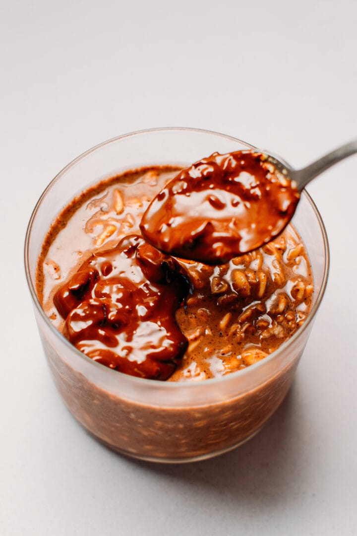 Pouring melted chocolate over overnight oats.