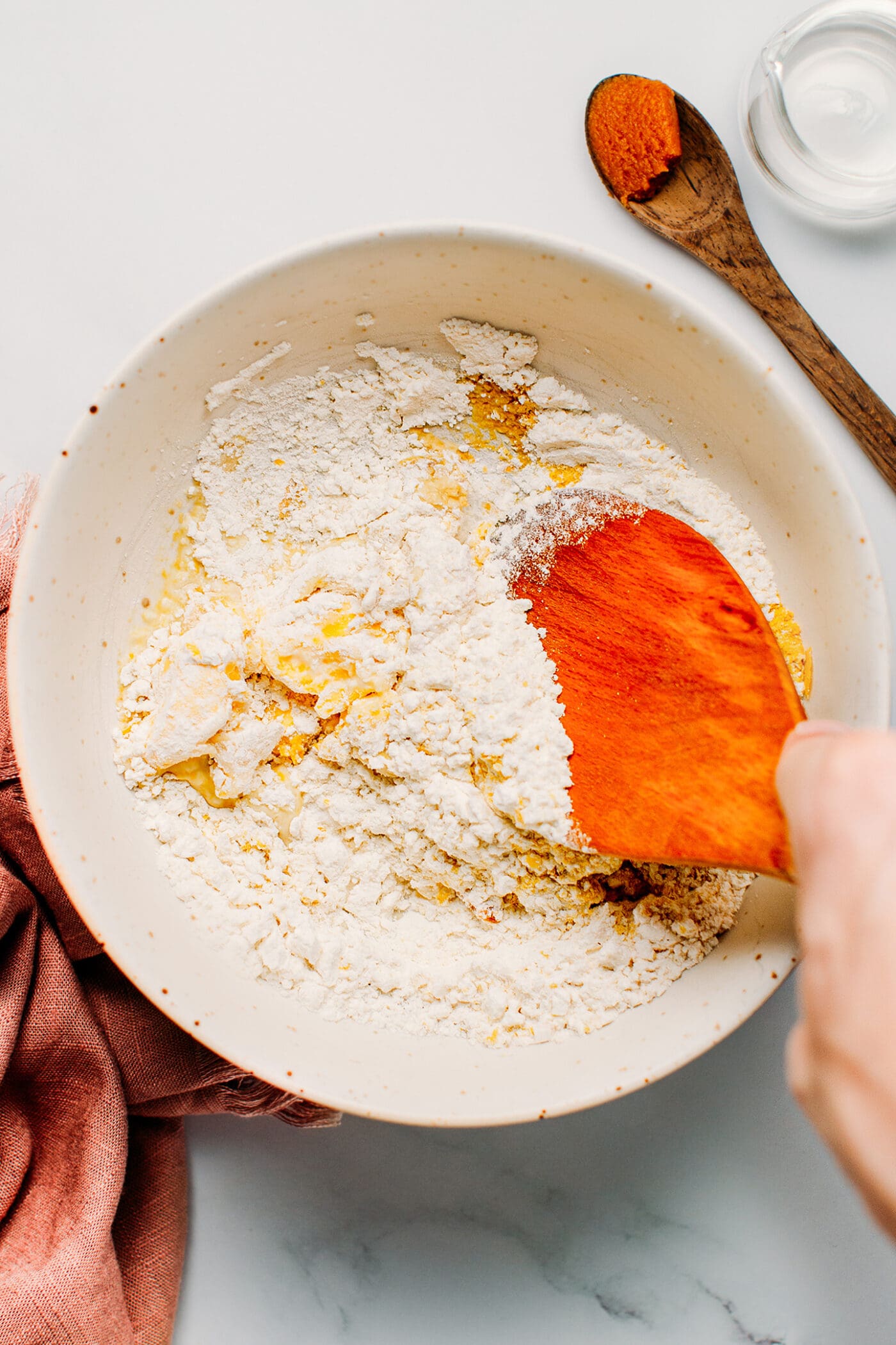 Mixing flour, dried herbs, miso, and vegan butter.