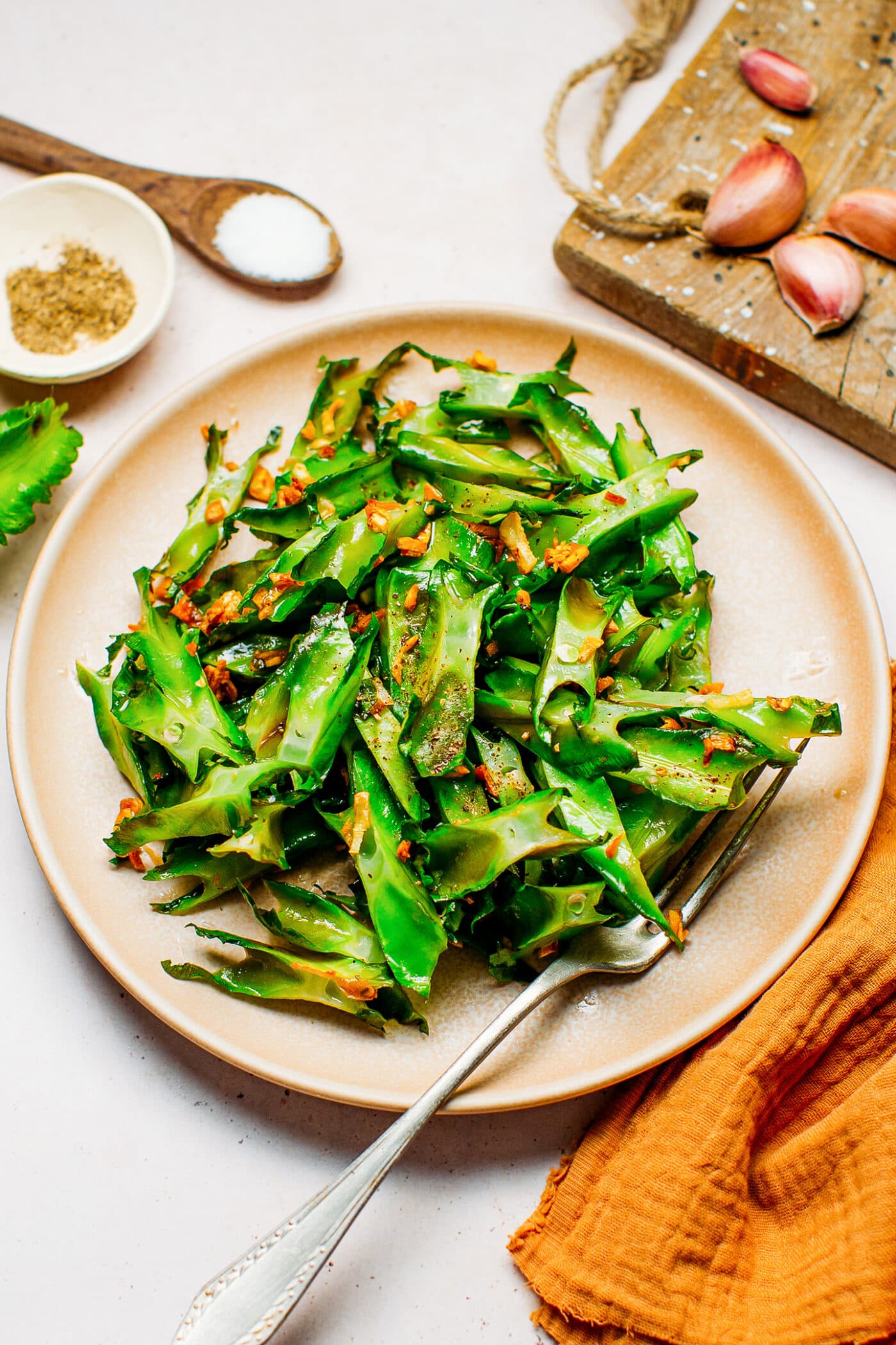Sautéed winged beans with crispy garlic on a plate.