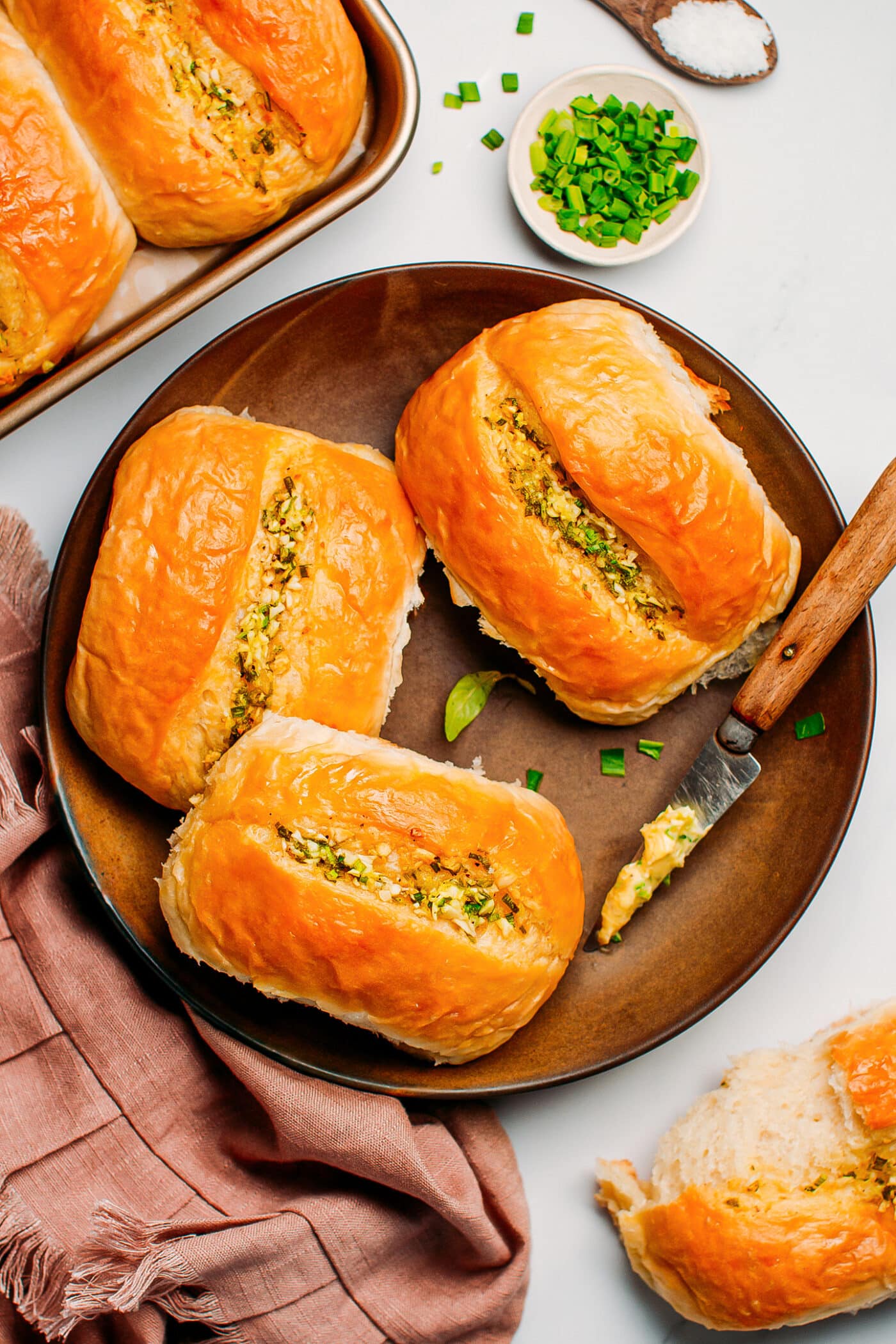 Dinner rolls with garlic butter on a plate.