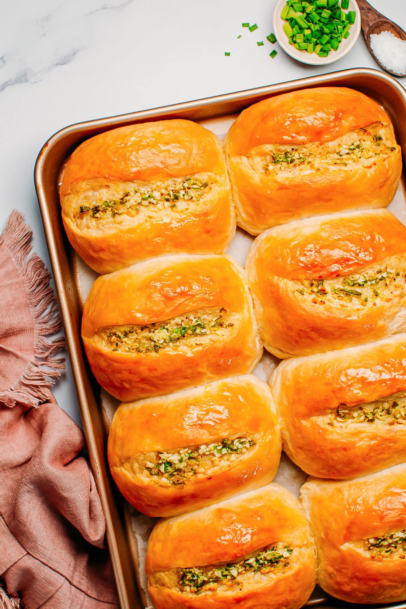 Baked garlic butter rolls on a baking sheet.