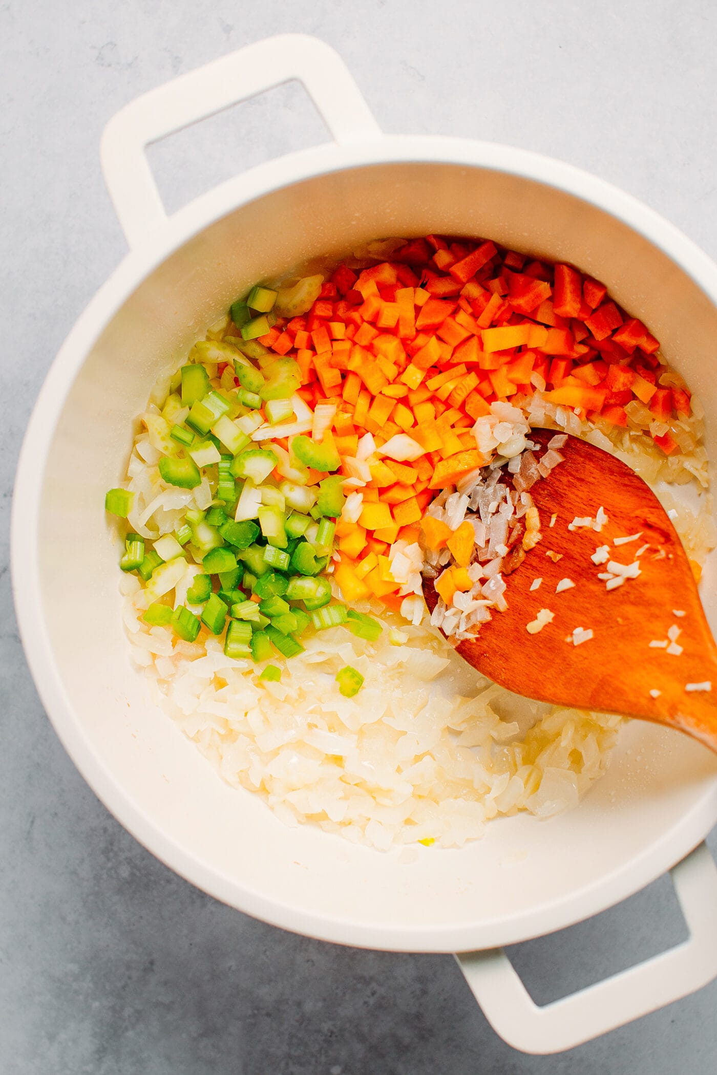 Celery, carrots, and onions in a pot.