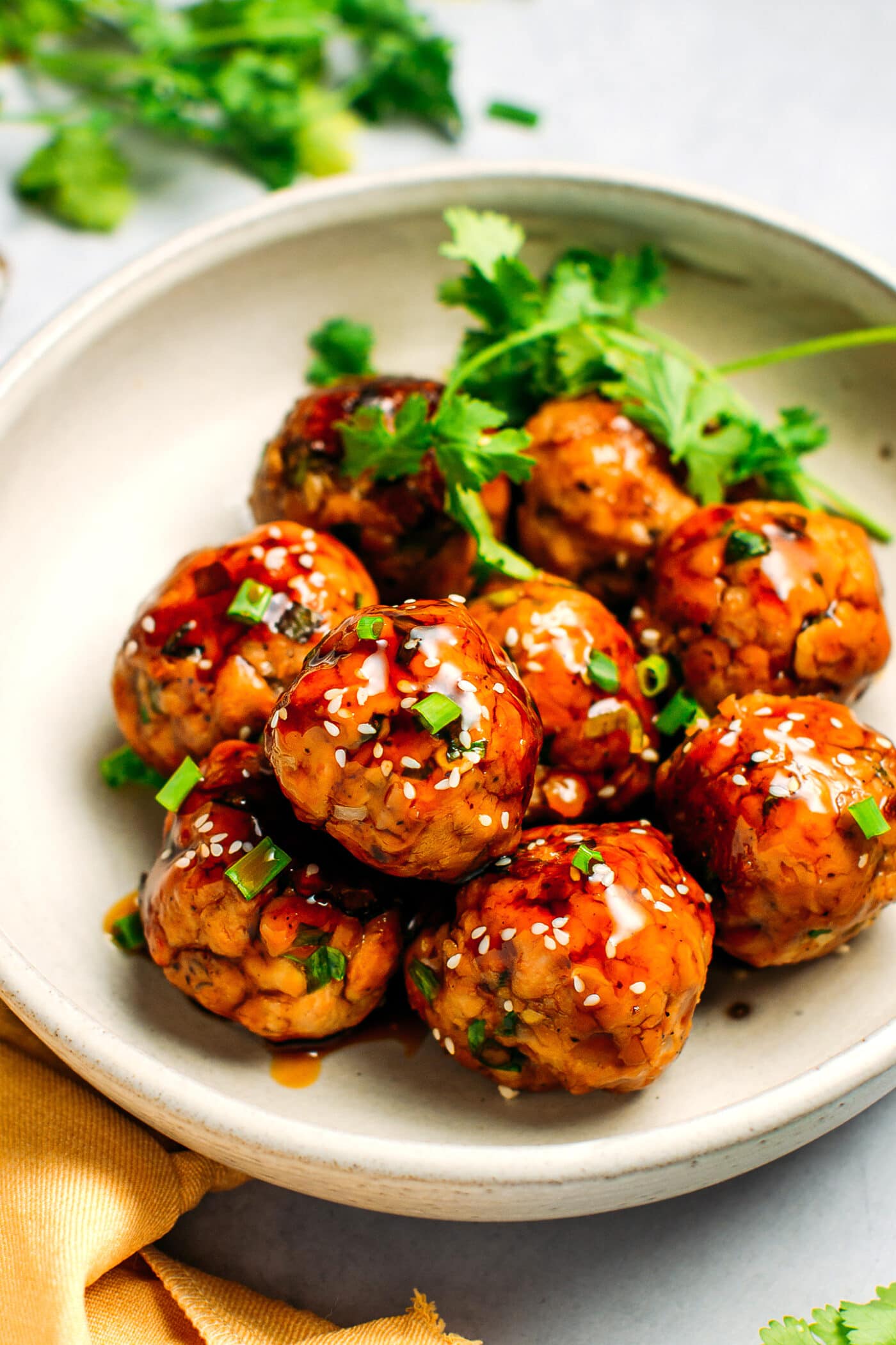 Teriyaki tempeh meatballs topped with sesame seeds and green onions.