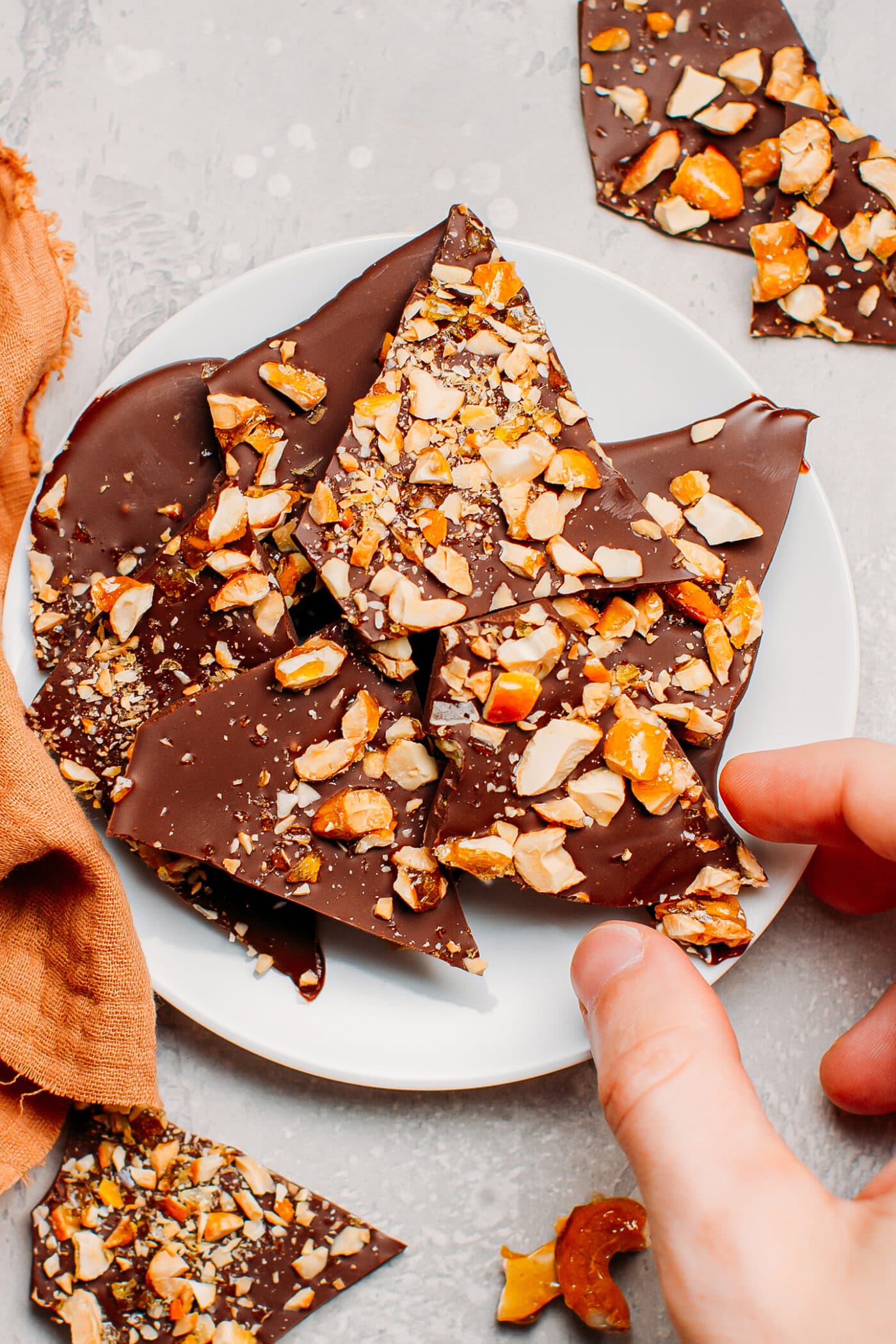 Hand picking a piece of chocolate bark.