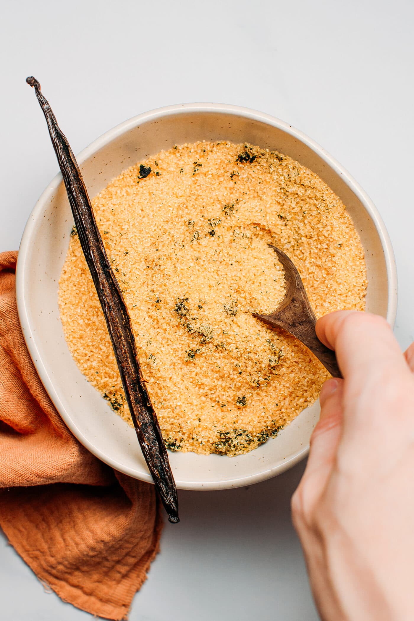 Stirring vanilla seeds into light brown sugar.