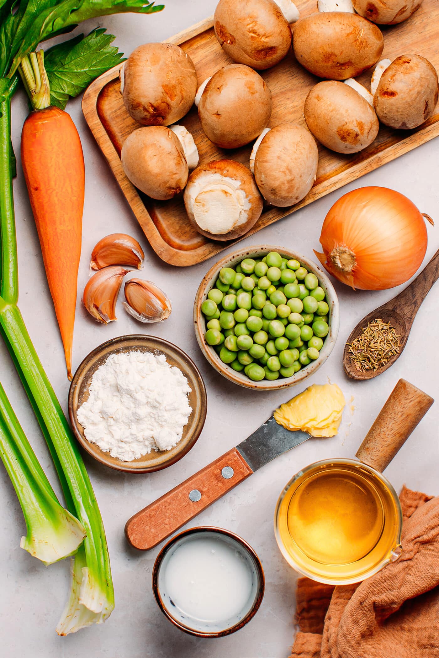 Ingredients like mushrooms, onion, carrots, green peas, and butter.